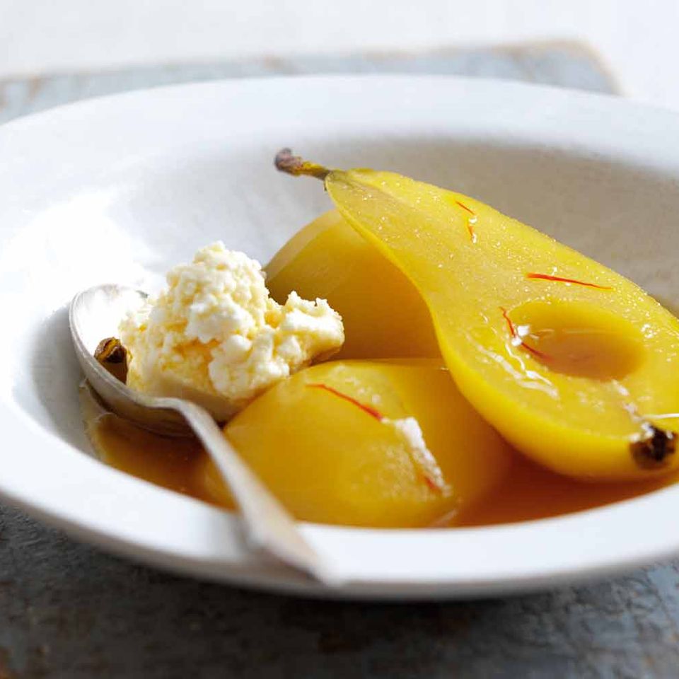 a bowl of pears with ice cream and a spoon in it .
