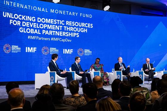 Panel discussion at an International Monetary Fund (IMF) event titled 'Unlocking Domestic Resources for Development Through Global Partnerships,' with five speakers seated on stage in front of a large audience.