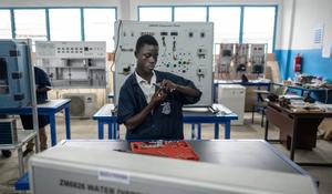A person in Ghana being trained to work on a Water Dispensing device.