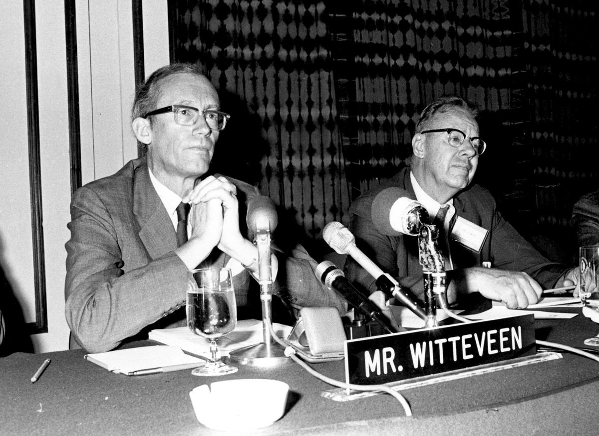 Black and white photo of Mr. Witteveen and two other men sitting at a conference table with microphones, taken during an event in 1973.