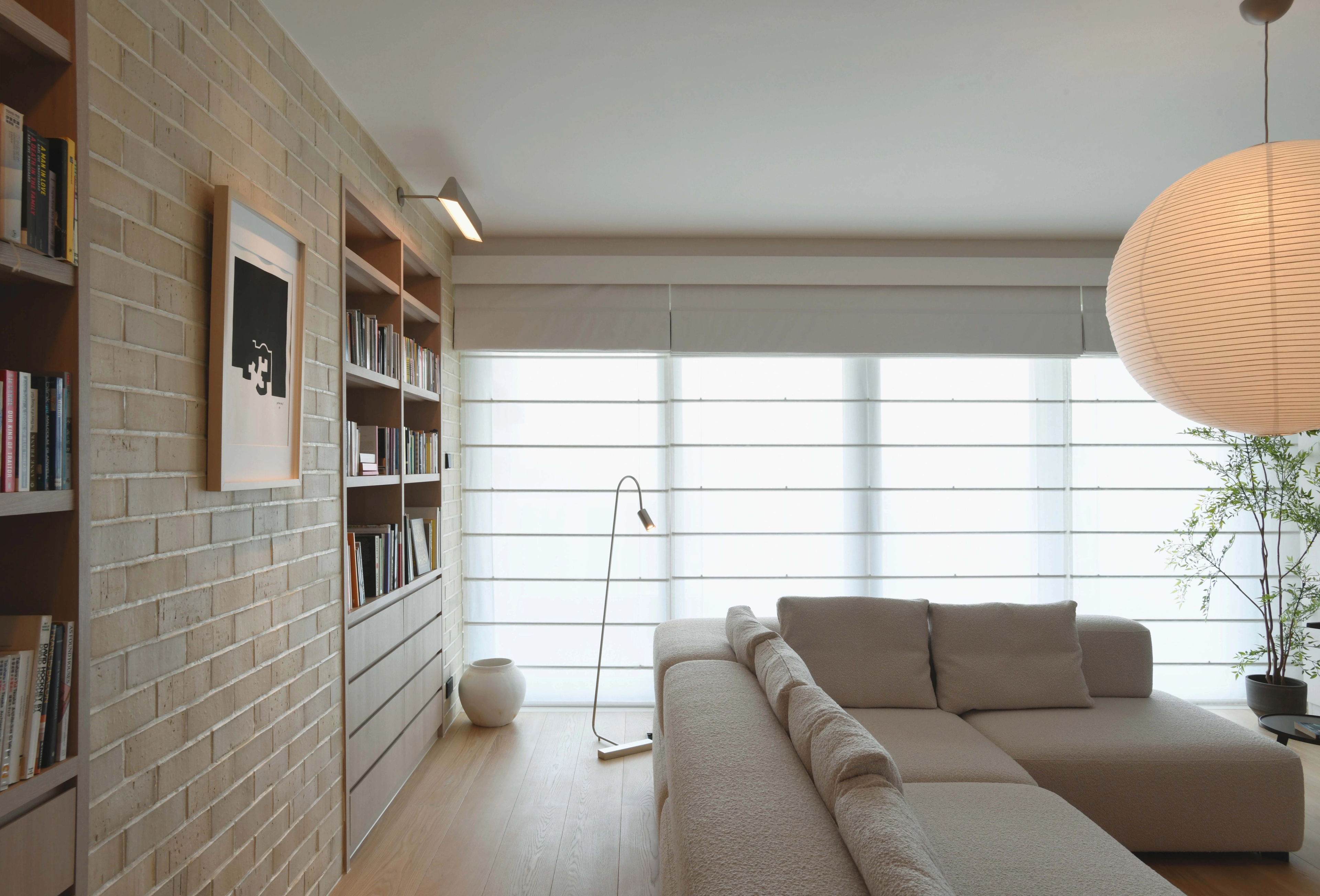 cozy living room with brick wall and sheer roman blinds