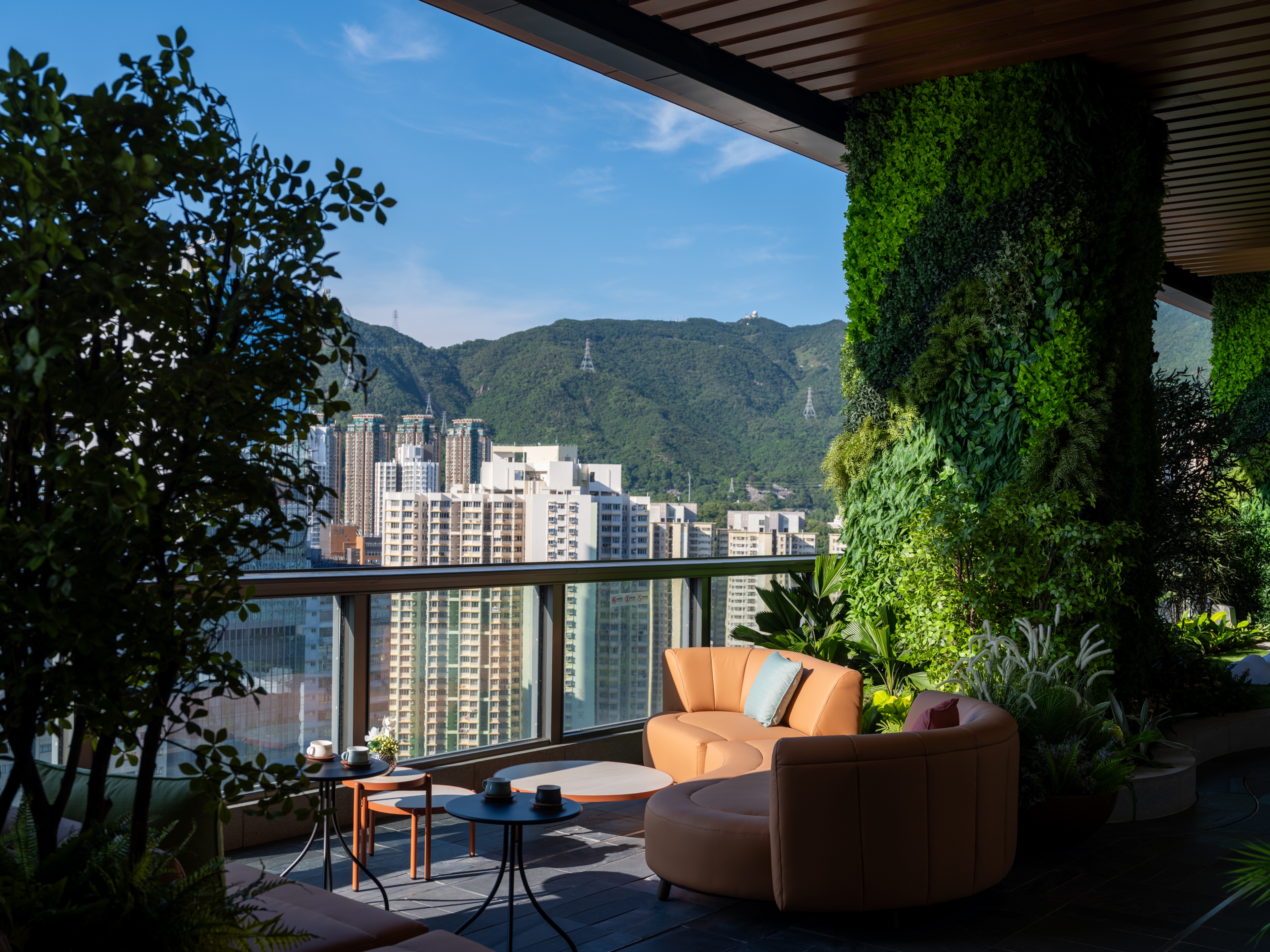 Lounge with natural sunlight and green column, set against picturesque mountain backdrop
