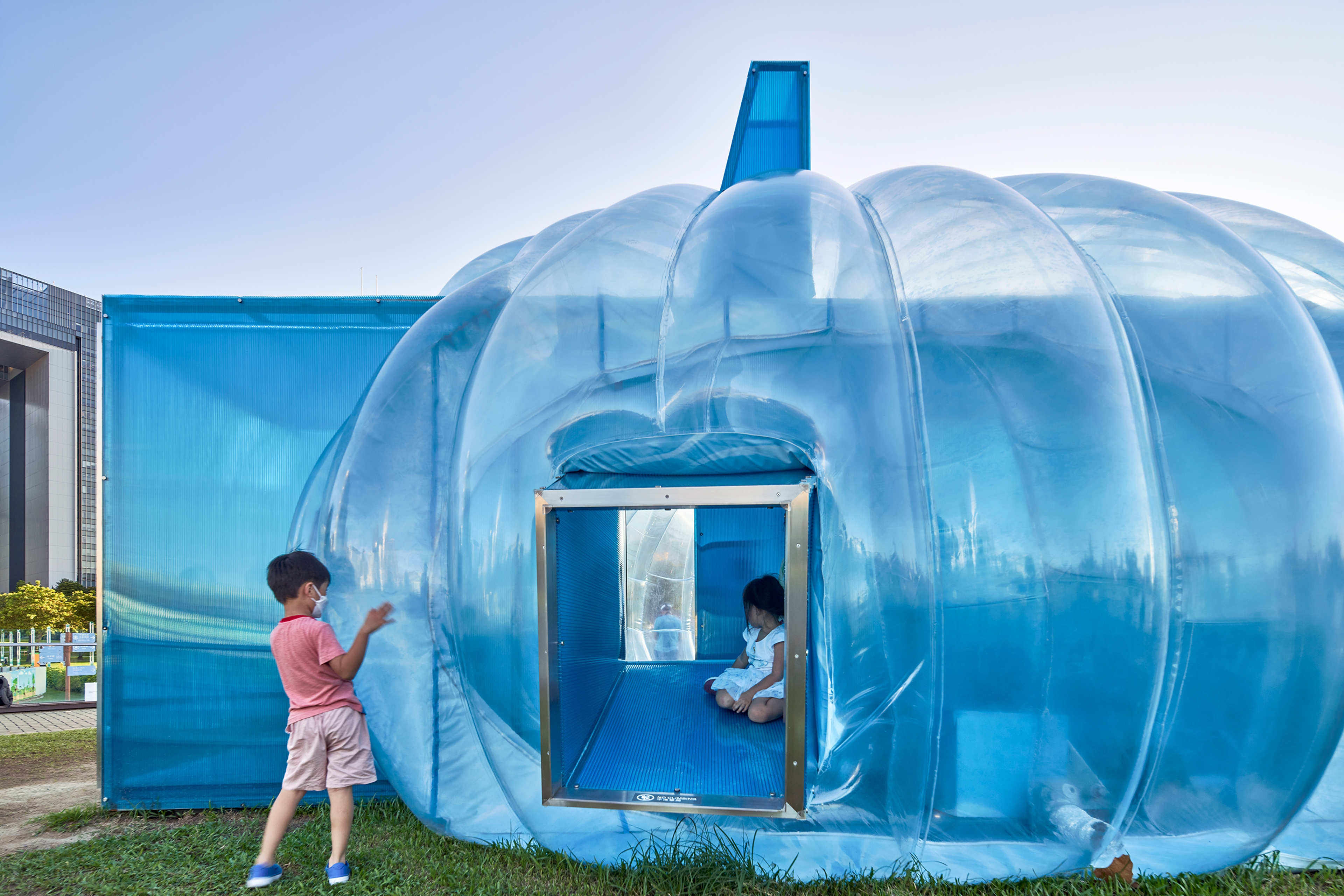 Temporary bubble art installation structure on Hong Kong harbour front with children playing