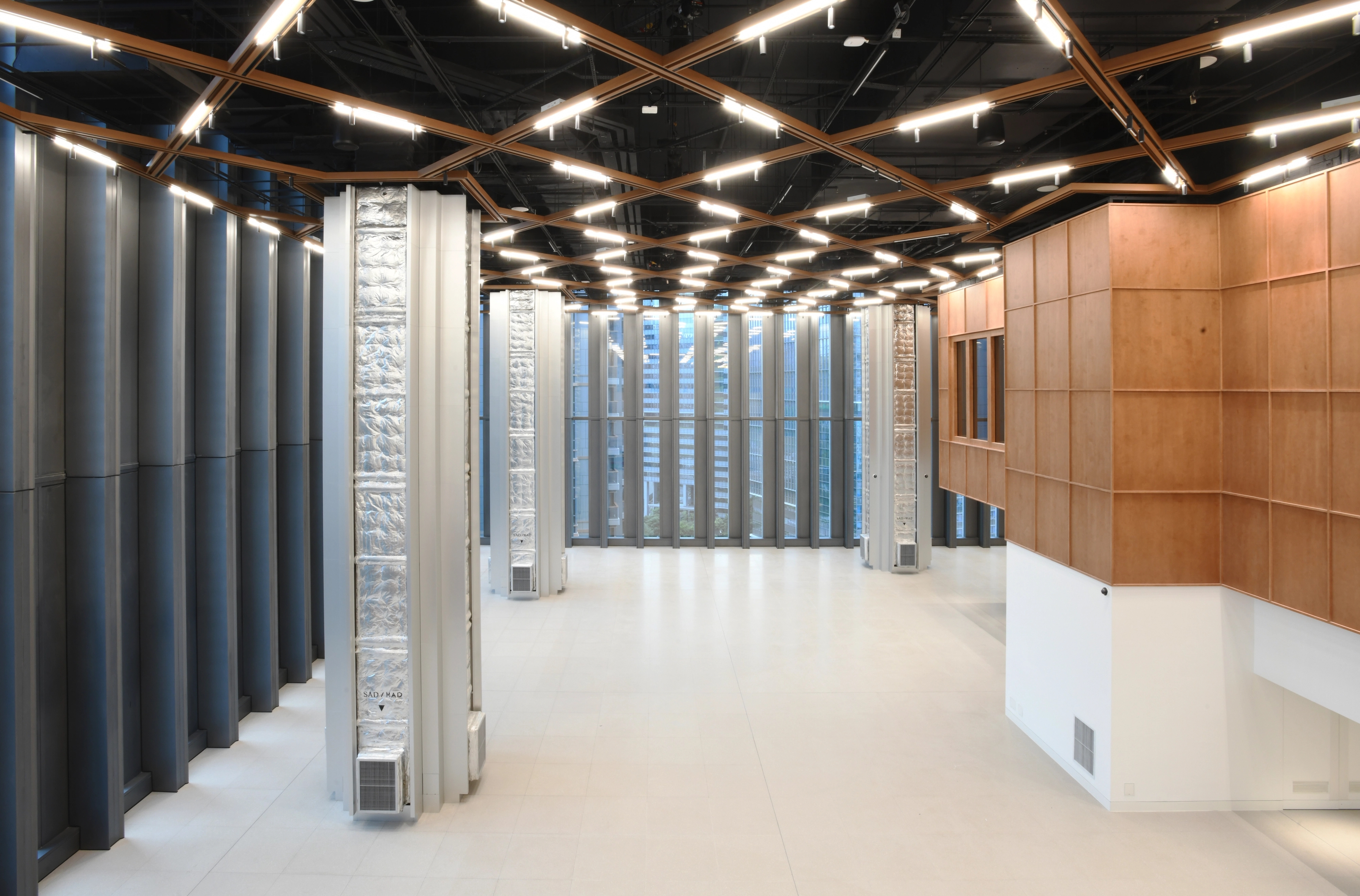 View of ninth floor sports hall with silver columns and timber grid ceiling