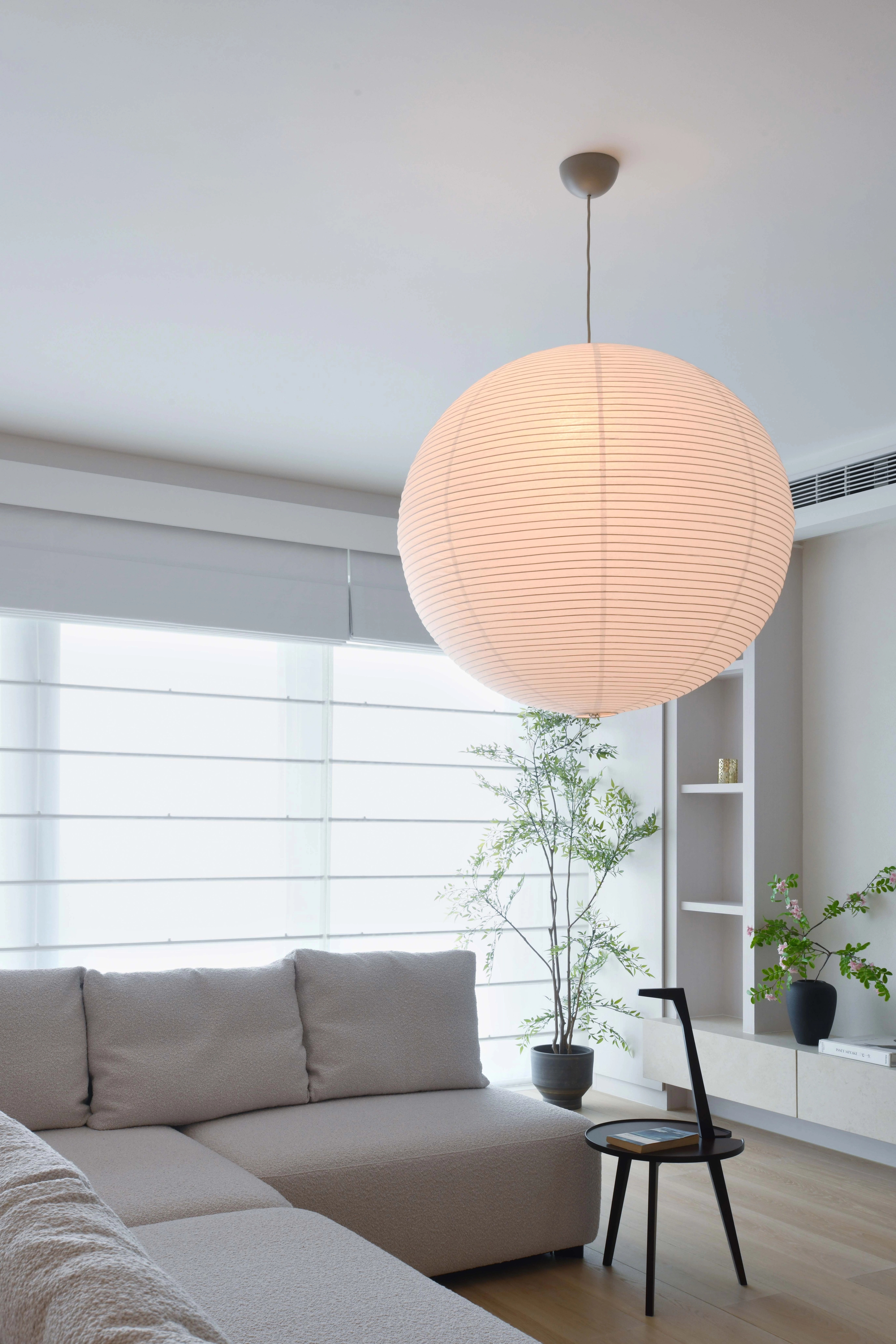built in white wood cabinet with sheer roman blinds and sofa