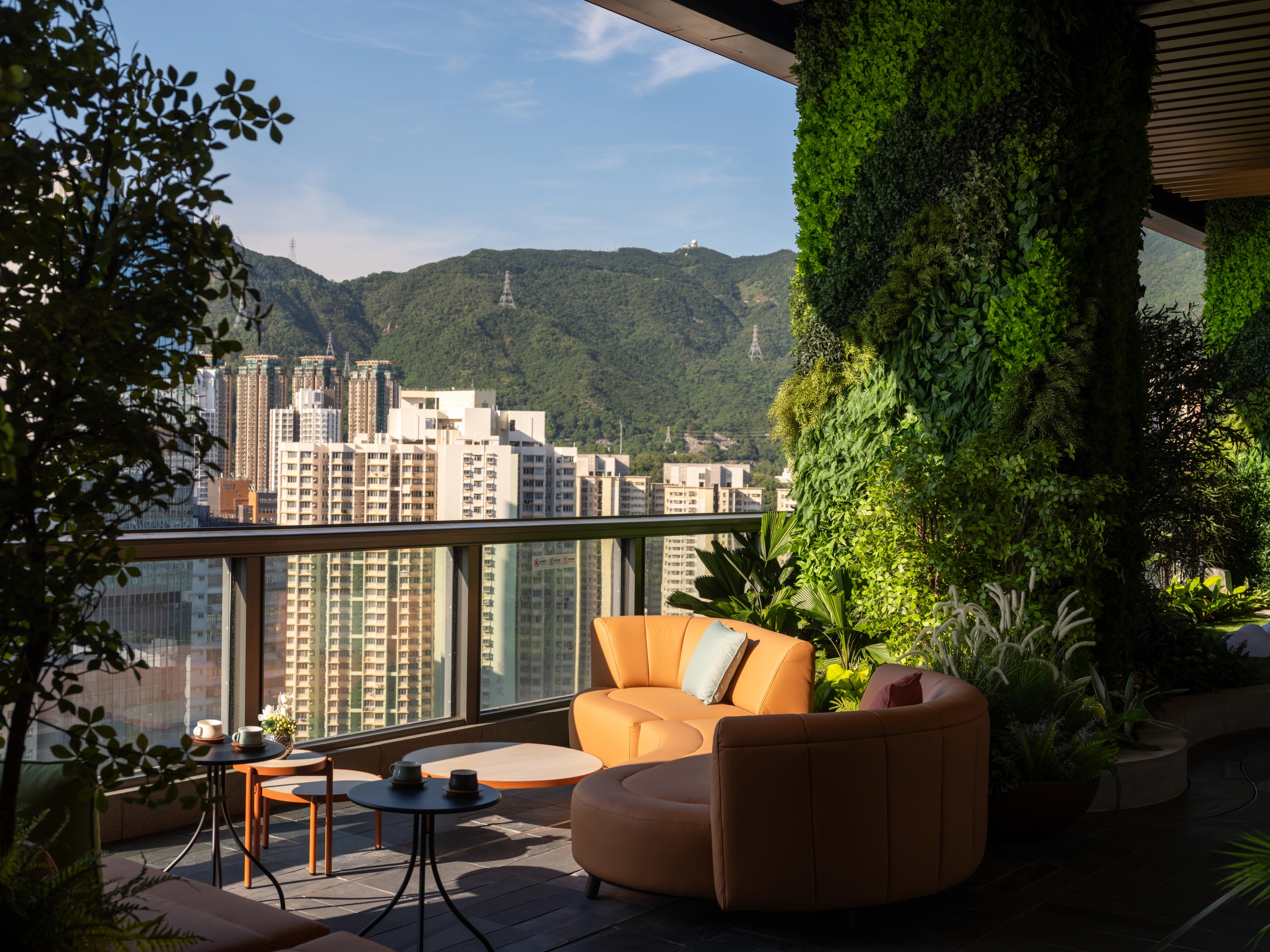 Lounge with natural sunlight and green column, set against picturesque mountain backdrop
