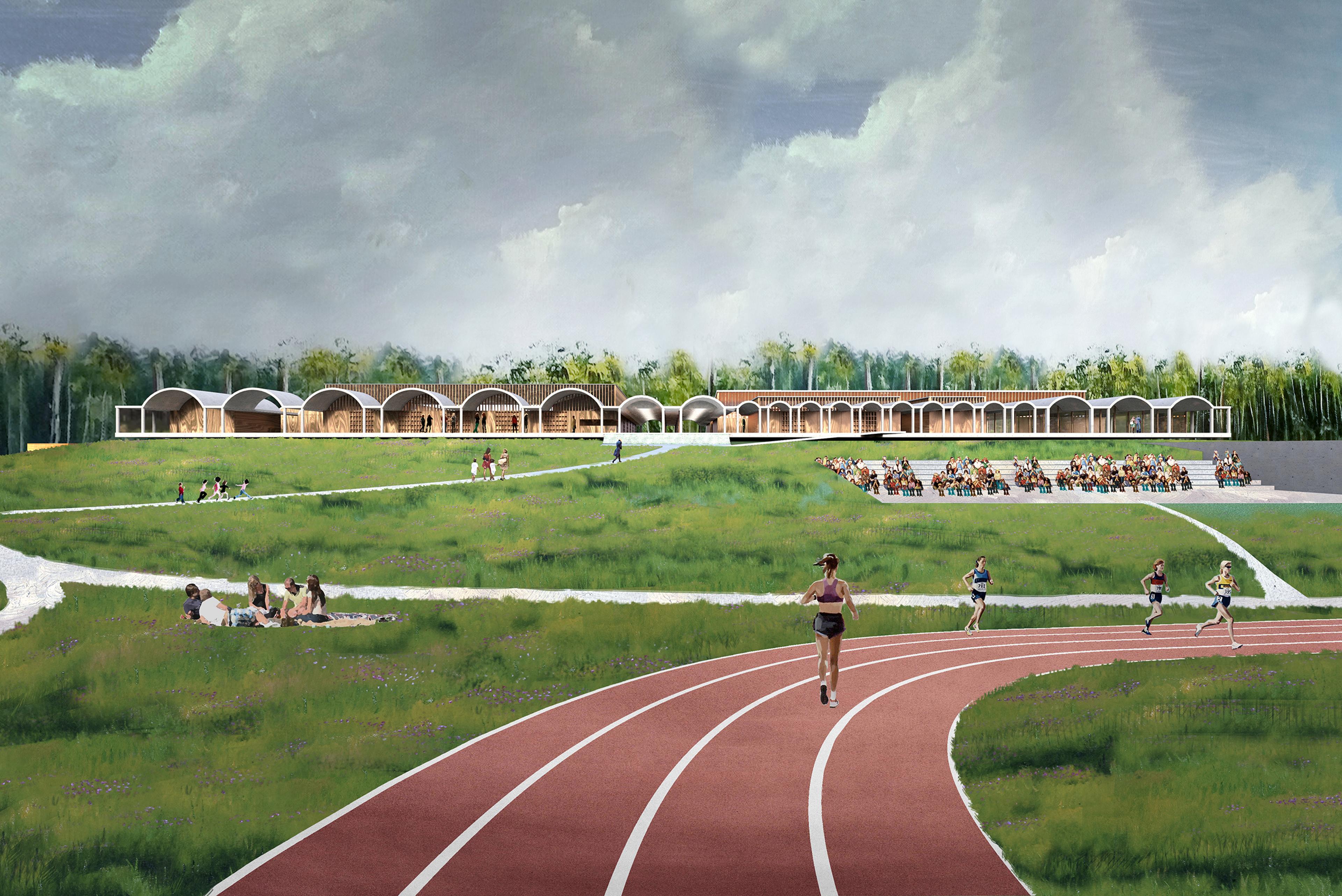 athletic track in a green field with structures in background