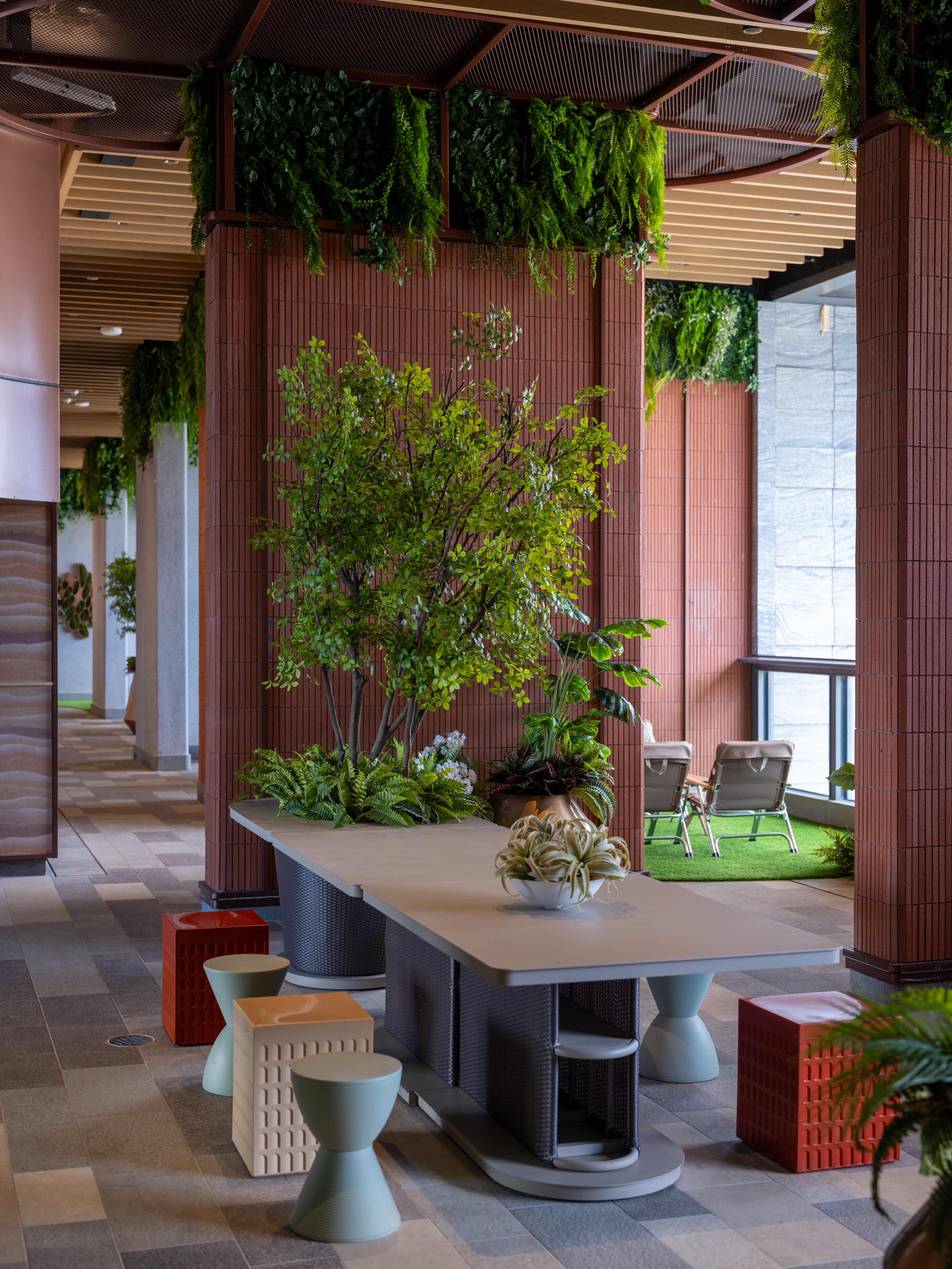 open dining area with terracotta tiled walls and lush greenery