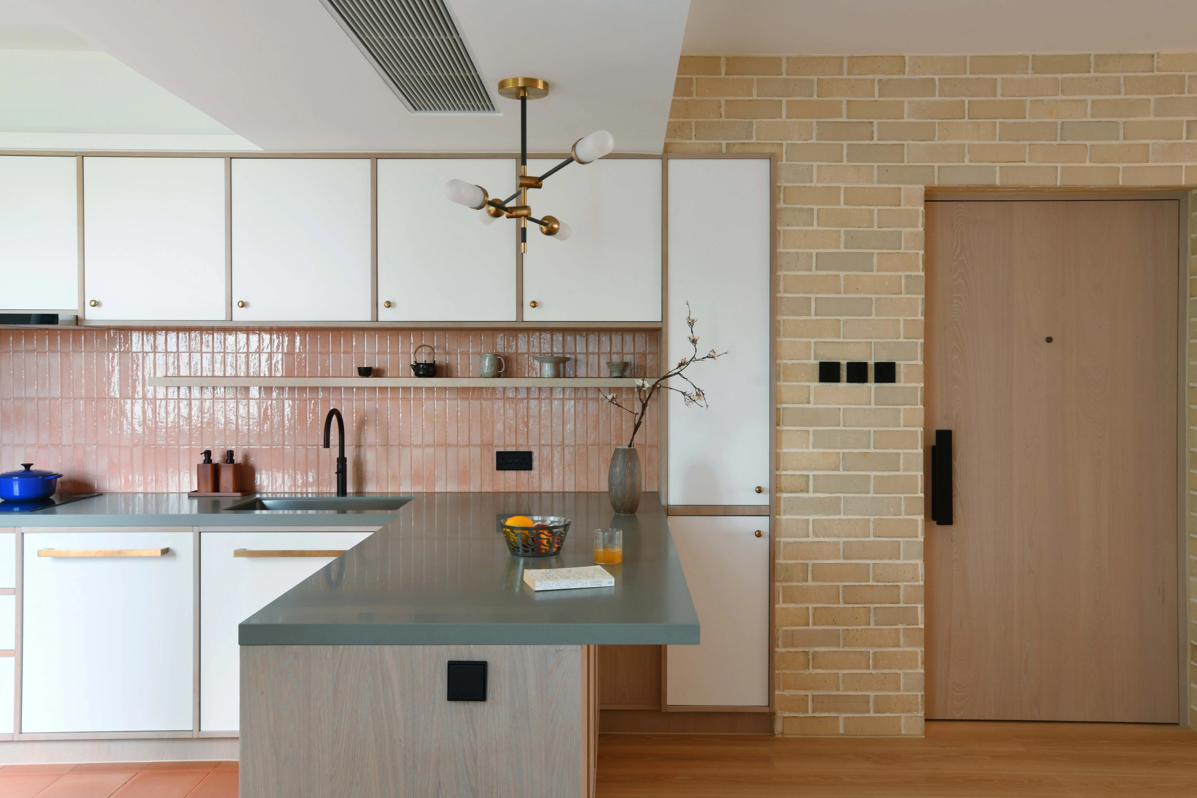 open kitchen with bar counter and pink glazed ceramic tiles