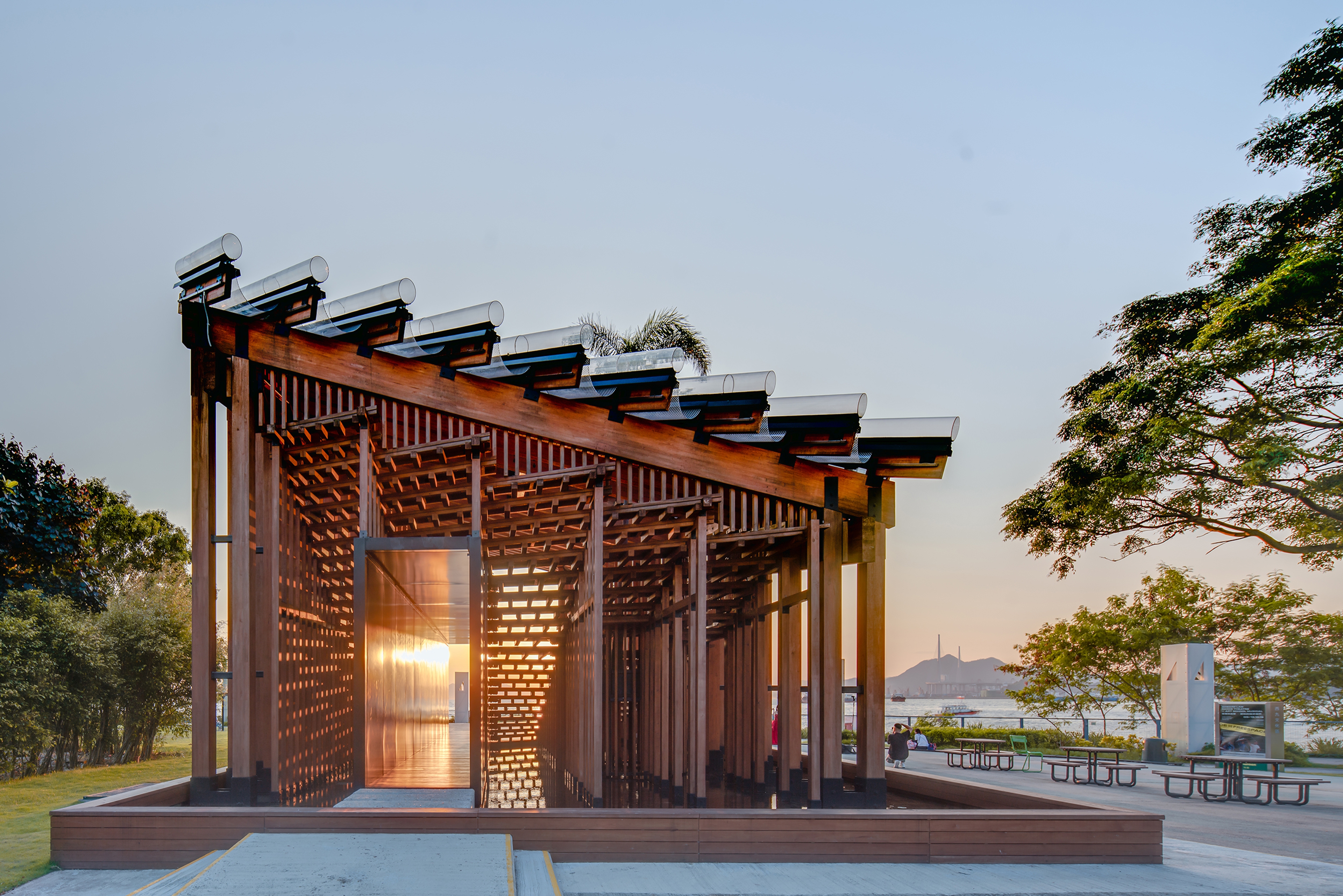 Pavilion in sunset with sky in background and trees and water