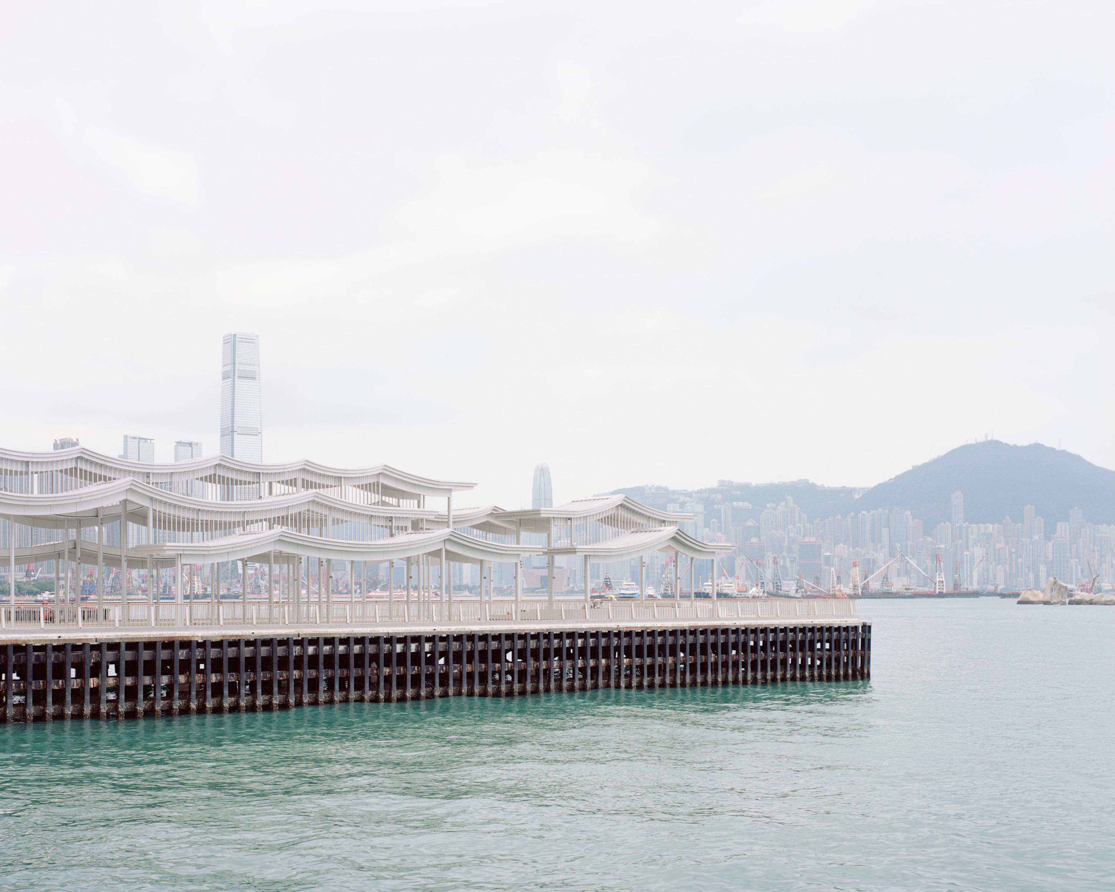 Elevation view of undulating pier canopy and Hong Kong skyline in background