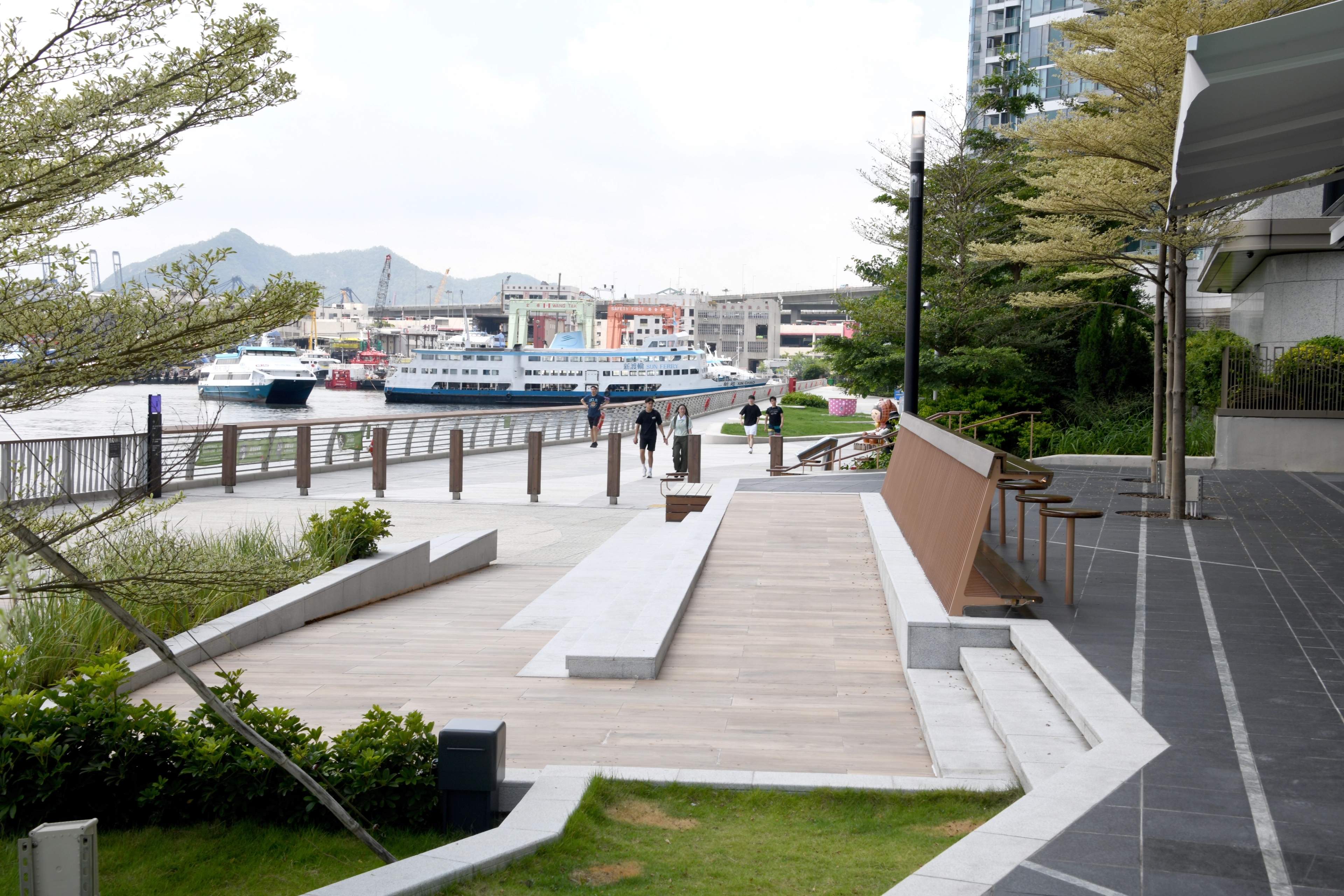 Promenade with wood ramp, stone steps and grass lawn