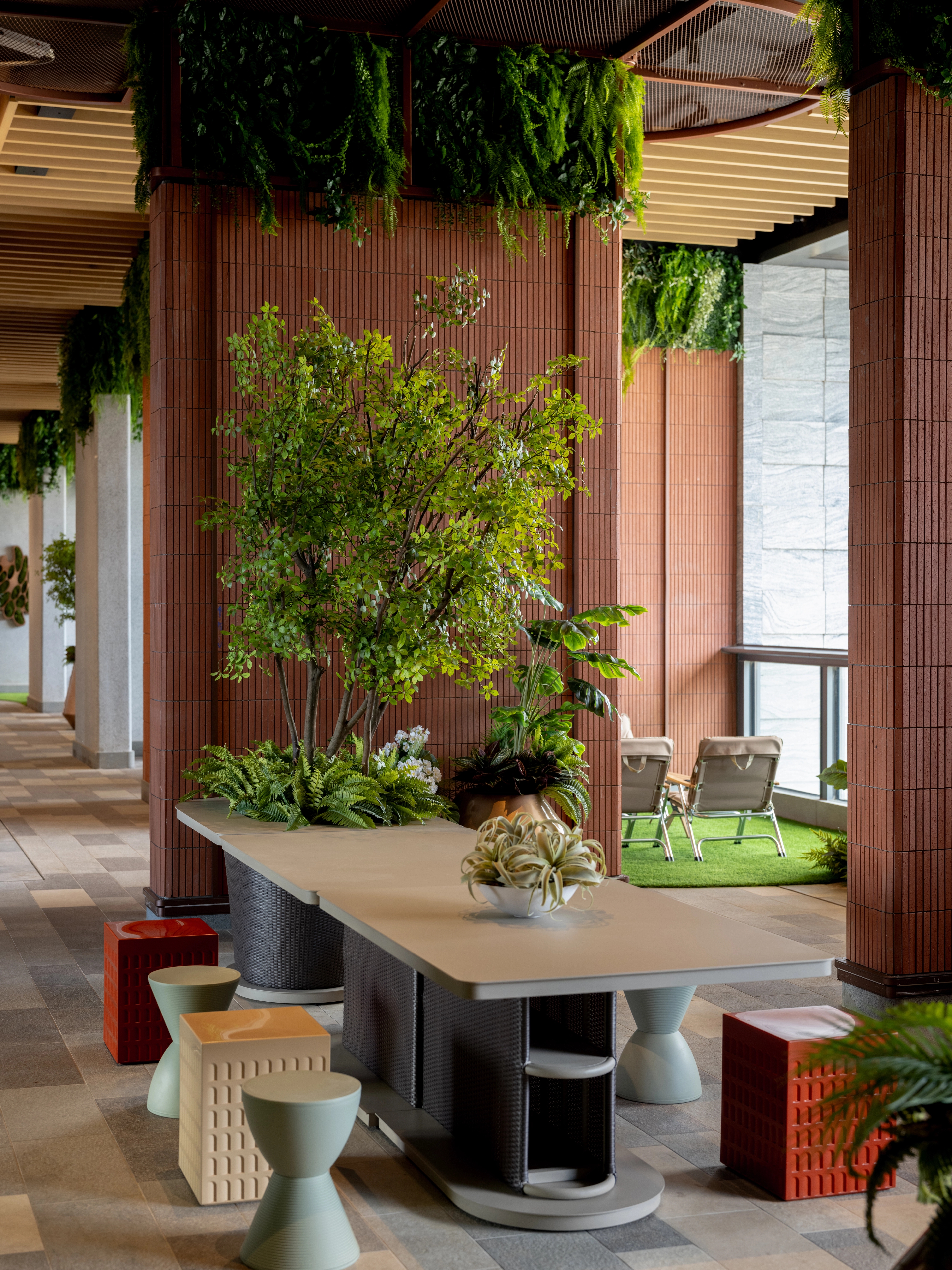 open dining area with terracotta tiled walls and lush greenery