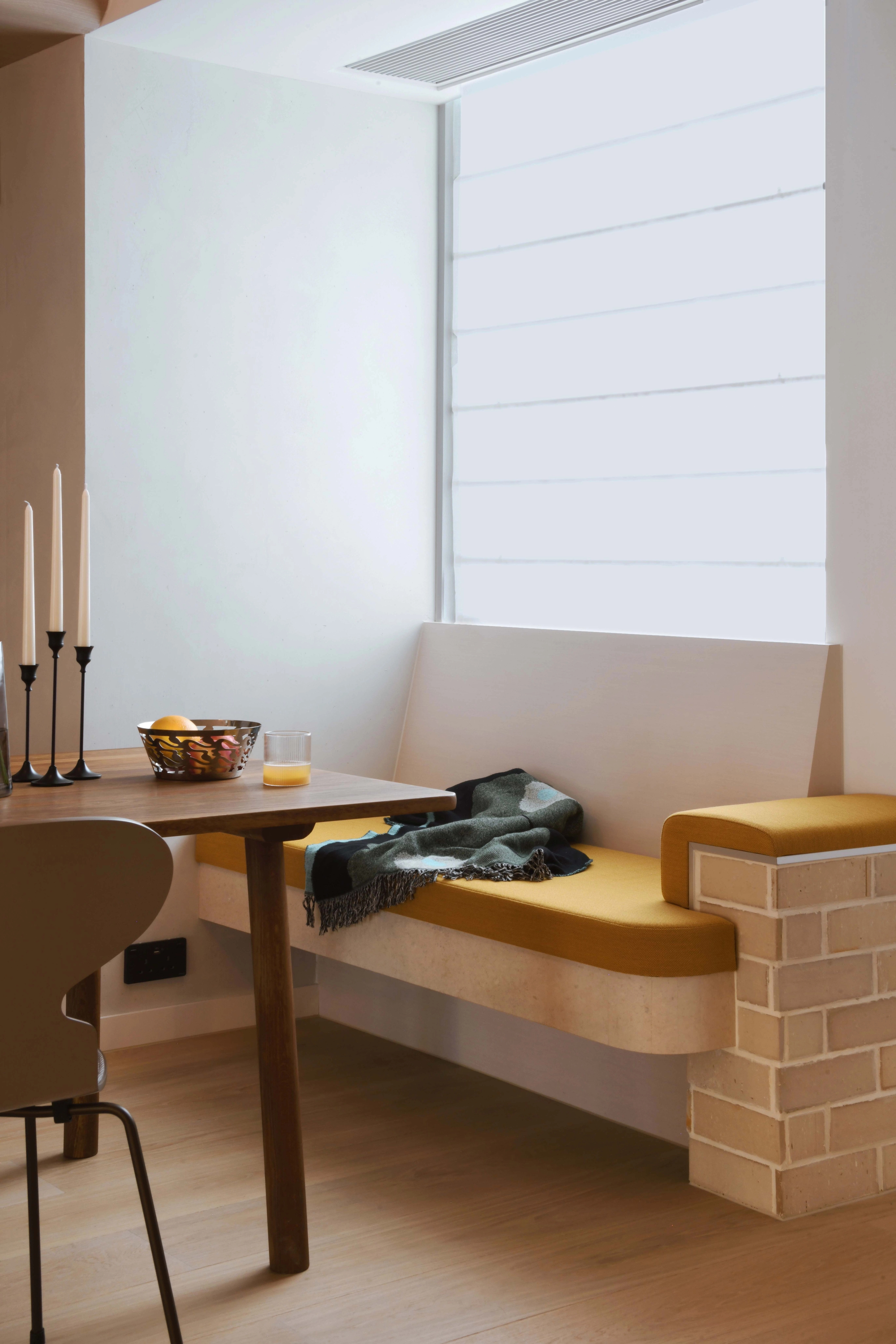 upholstered banquette with picture window and brick detail