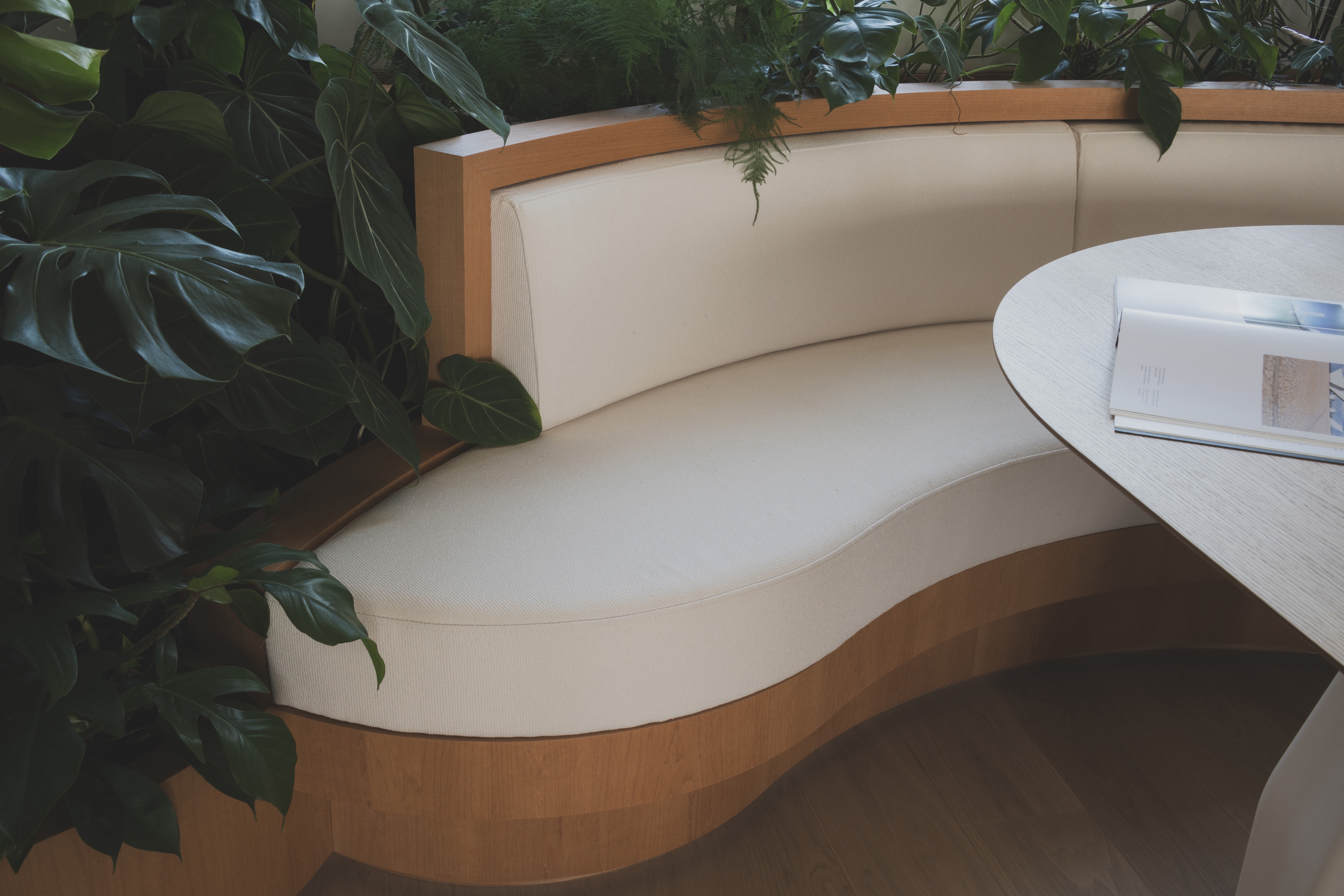 curved bench with upholstery and lush planting