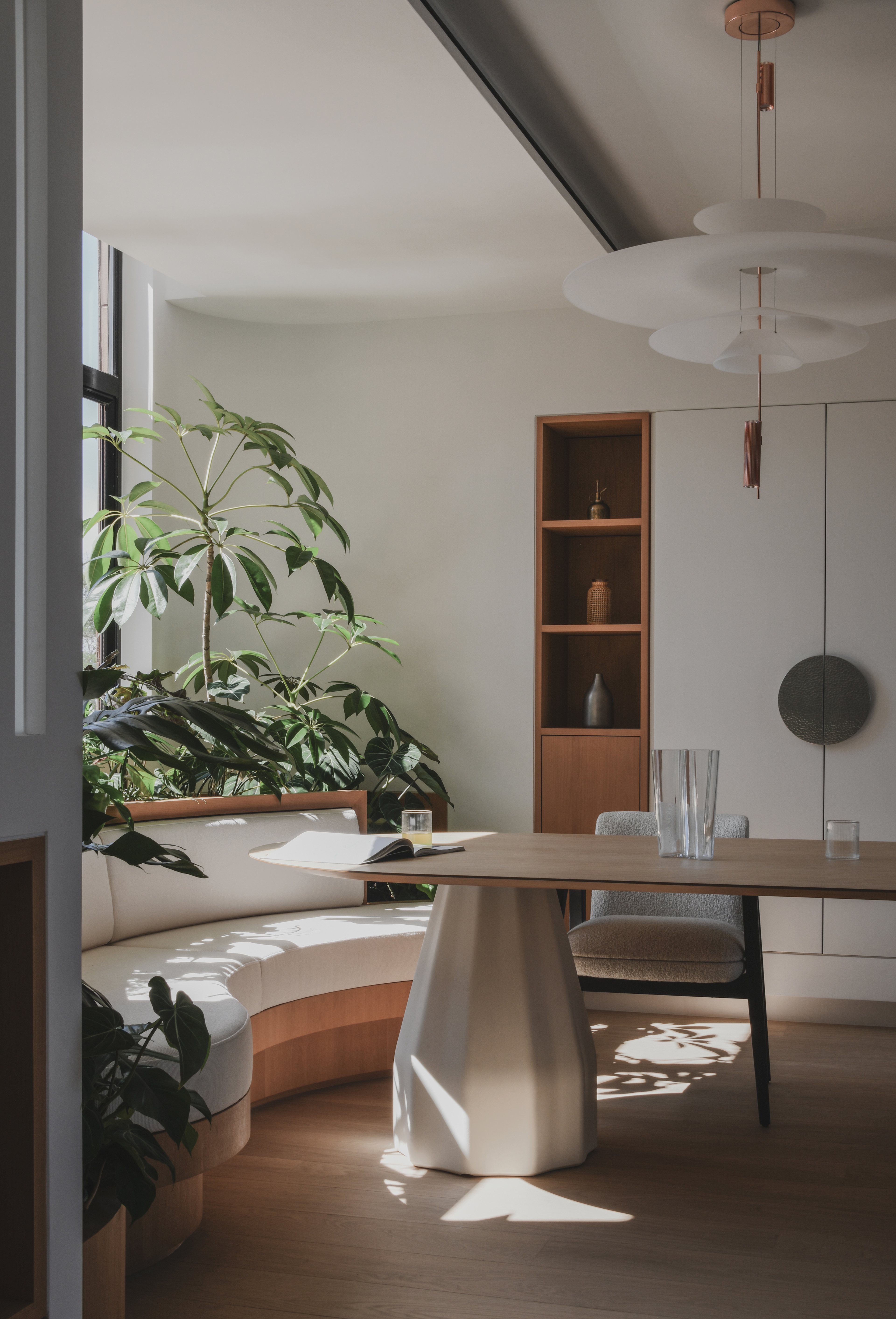 House interior with built in bench, dining table and plants