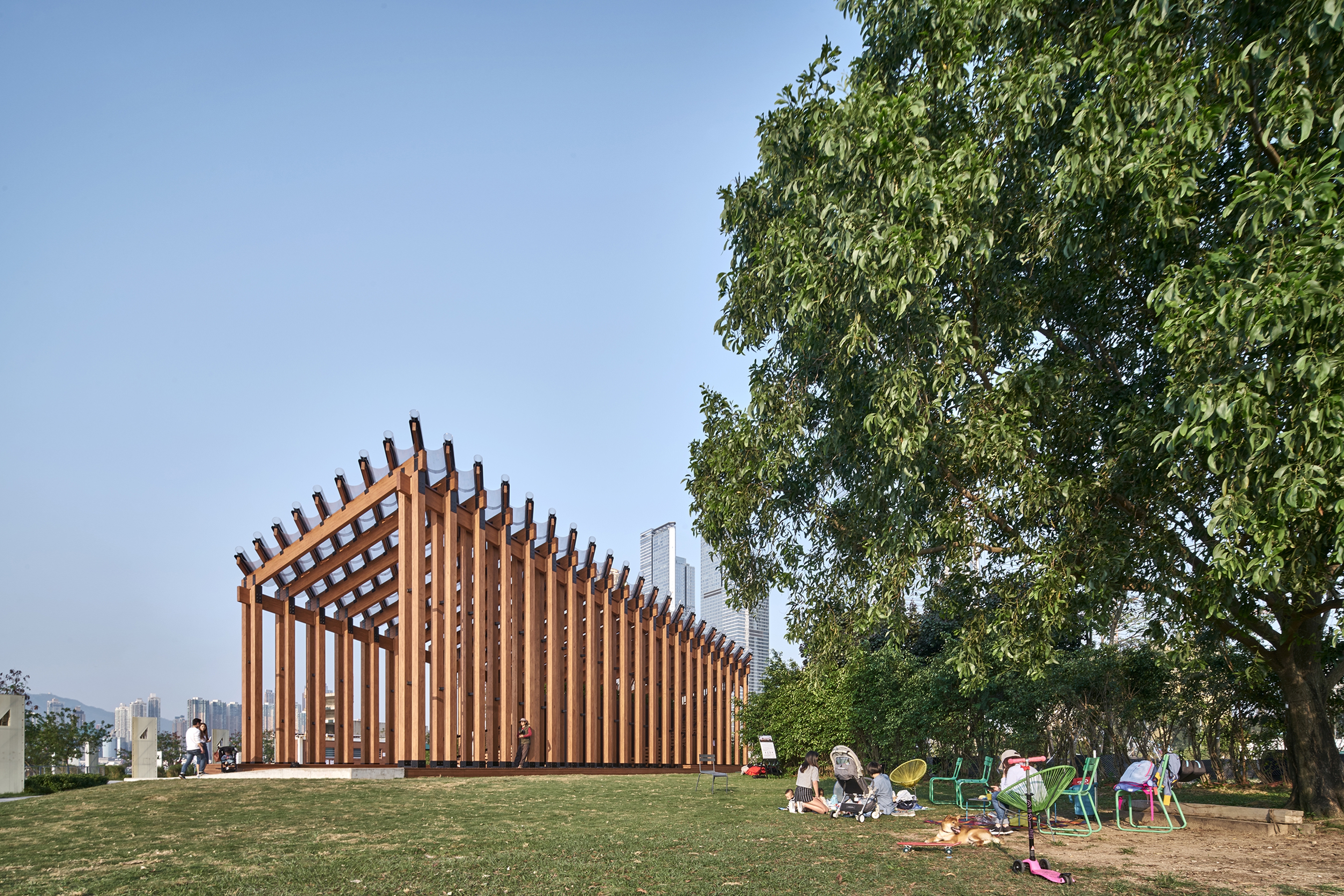 Pavilion structure in daylight with sky in background and trees along harbourfront 