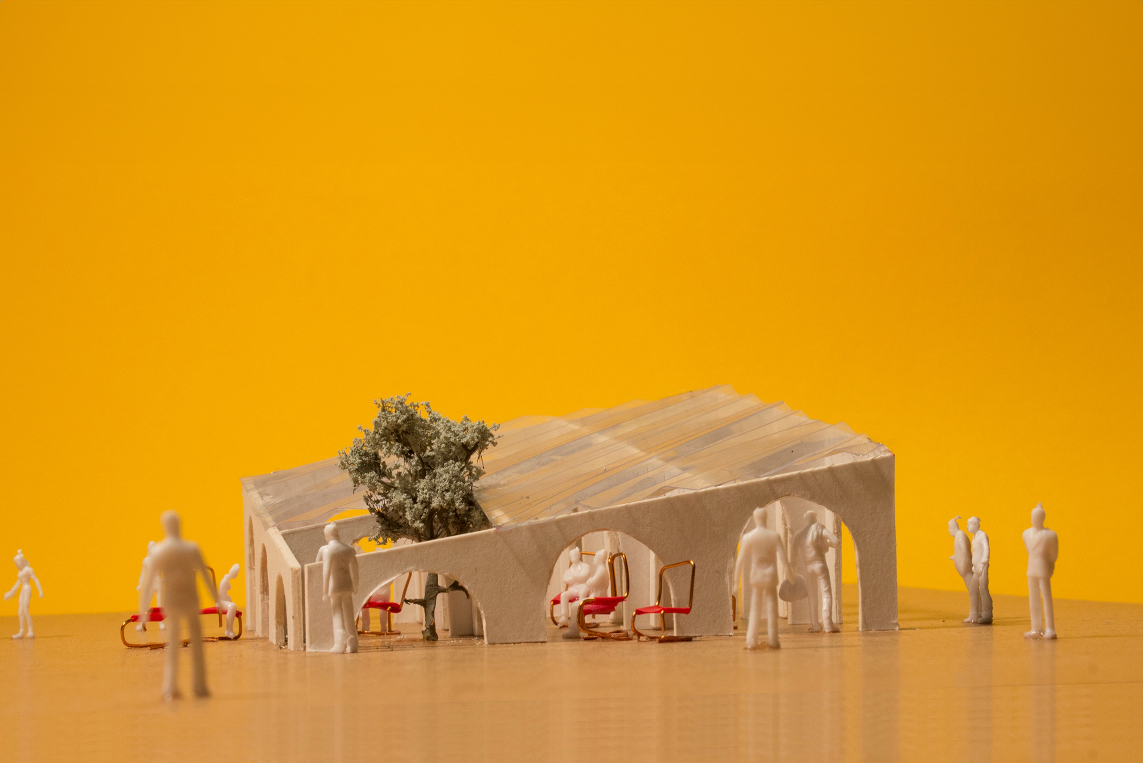 Architectural model of pavilion with chairs and people with a yellow background 