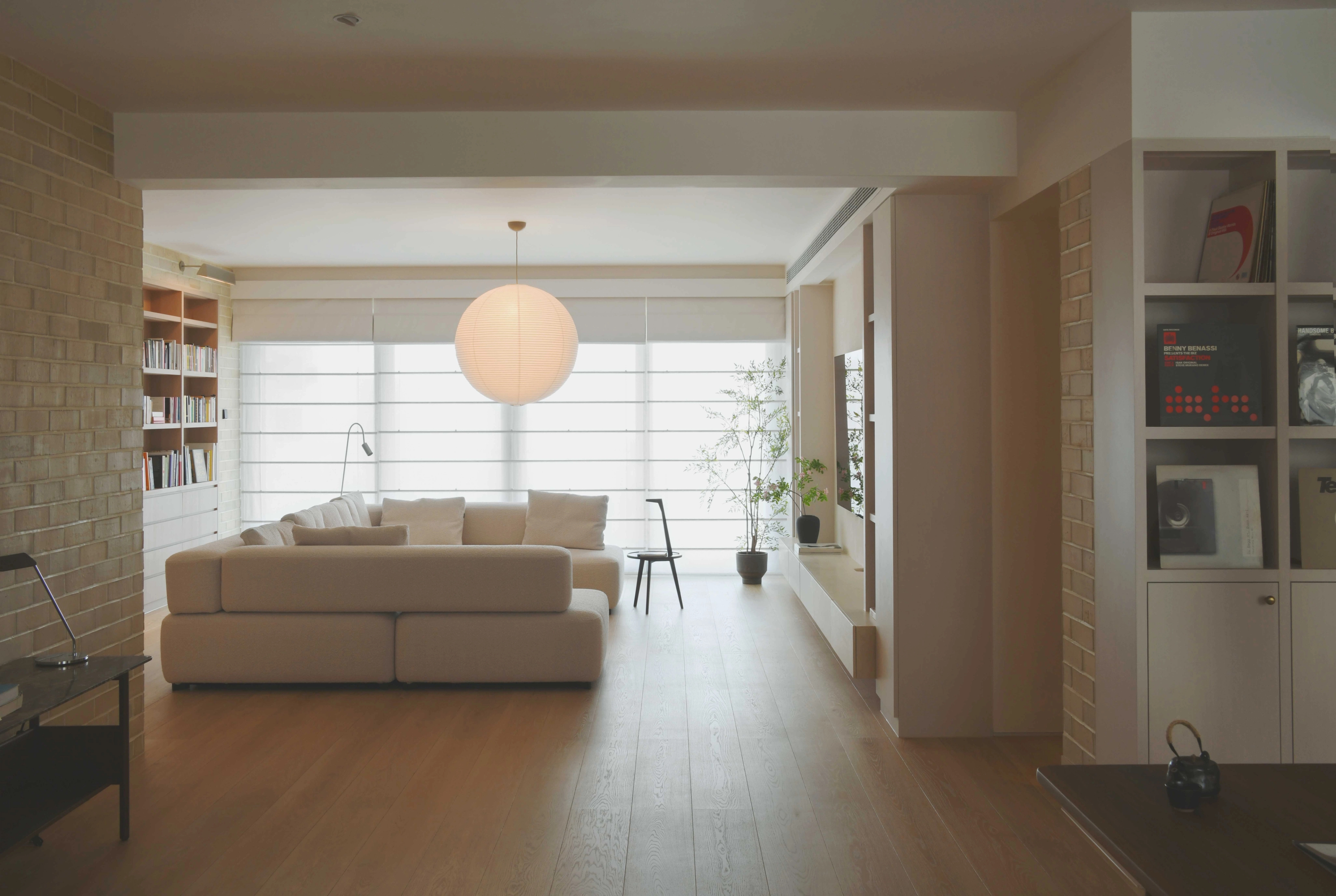 living room with brick wall and sheer roman blind