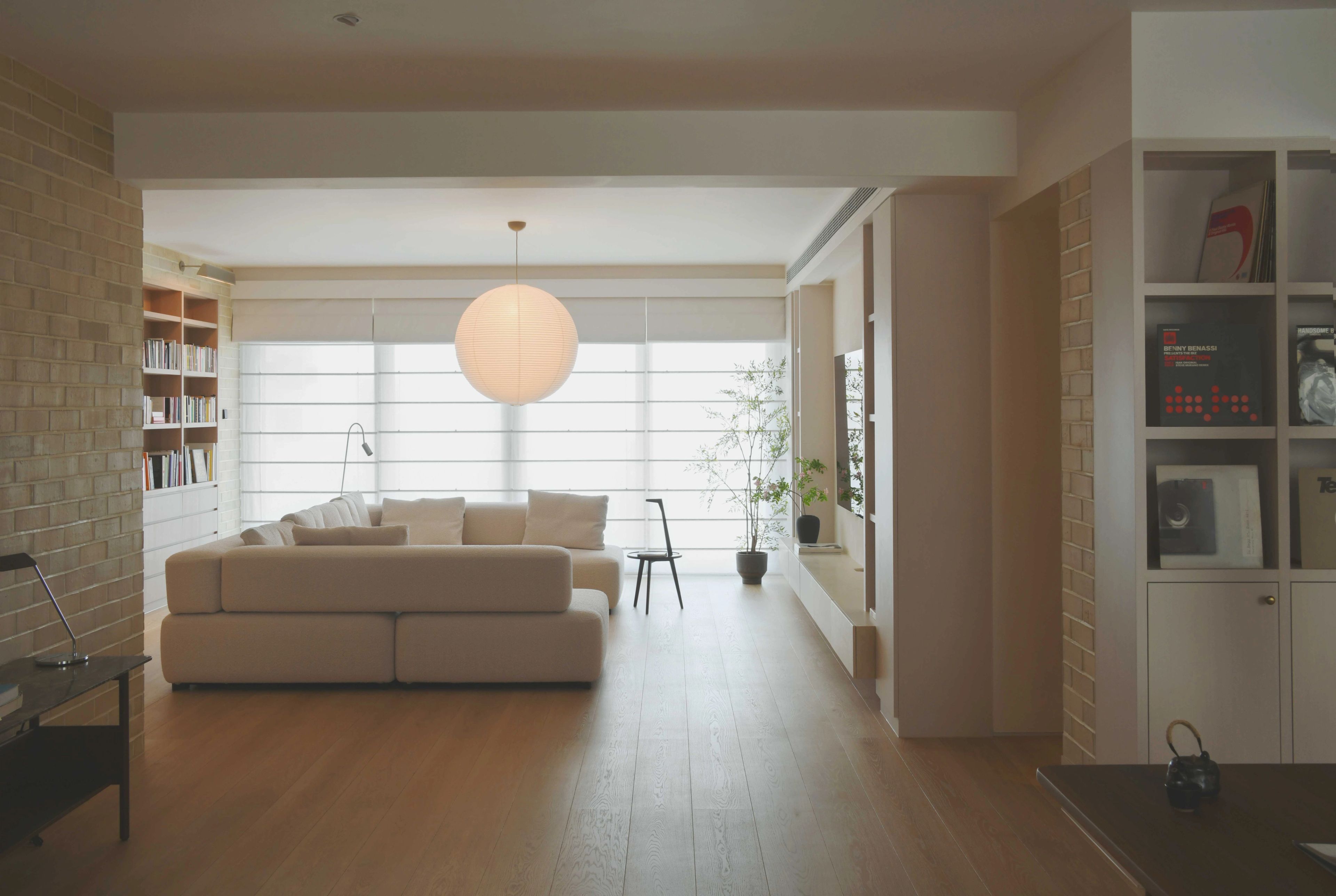 living room with brick wall and sheer roman blind