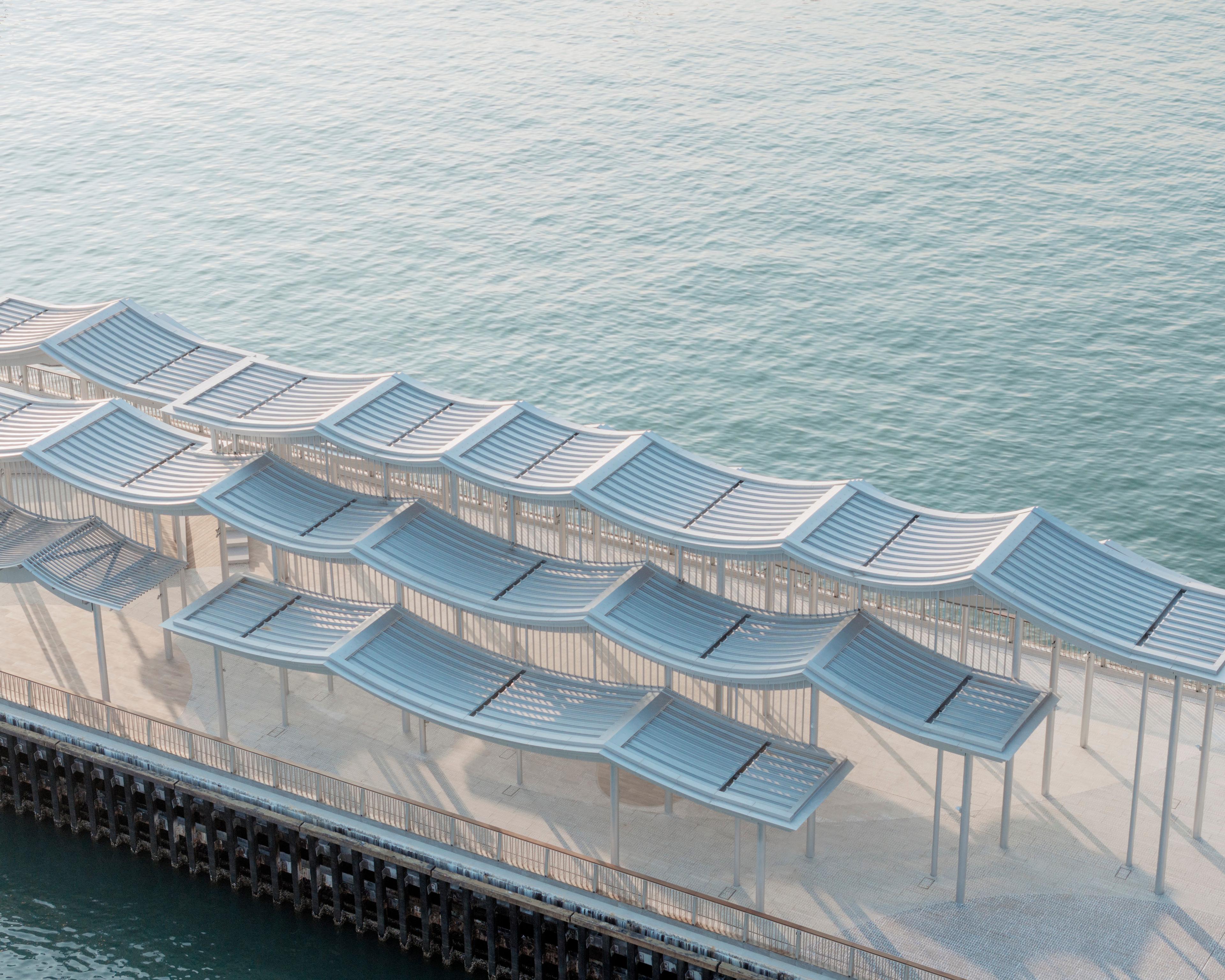 Aerial view of undulating pier canopy roof and water