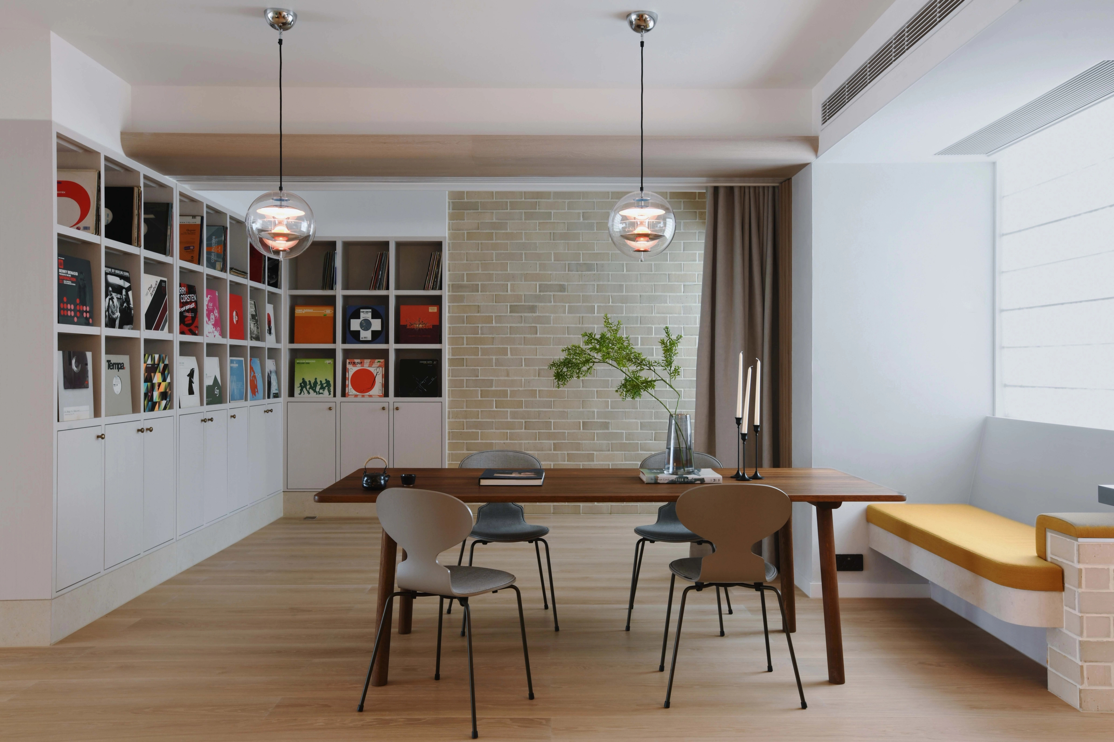 dining table with banquette and built in shelf with colorful records
