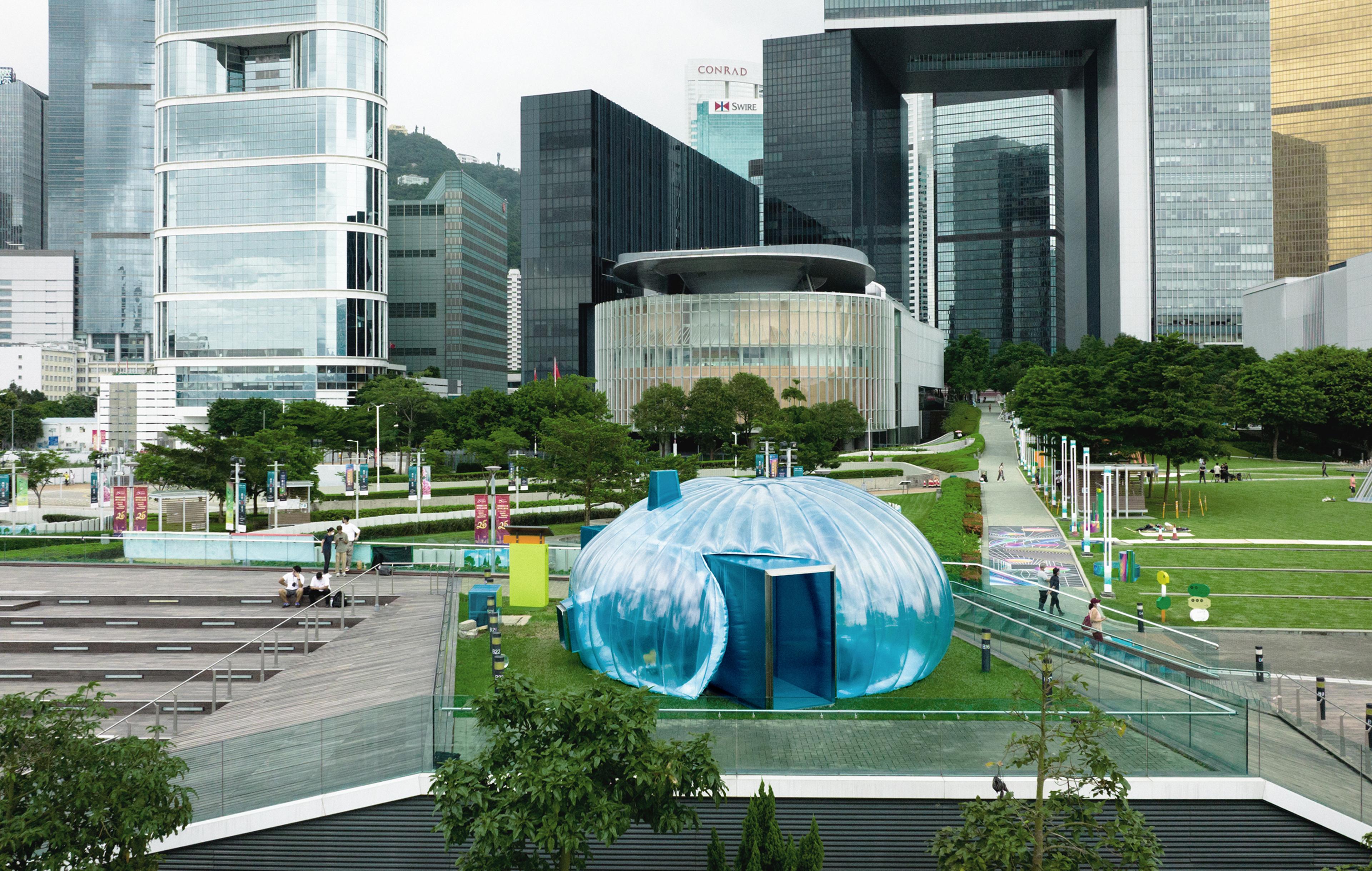 Temporary bubble art installation structure on Hong Kong harbour front with buildings in background
