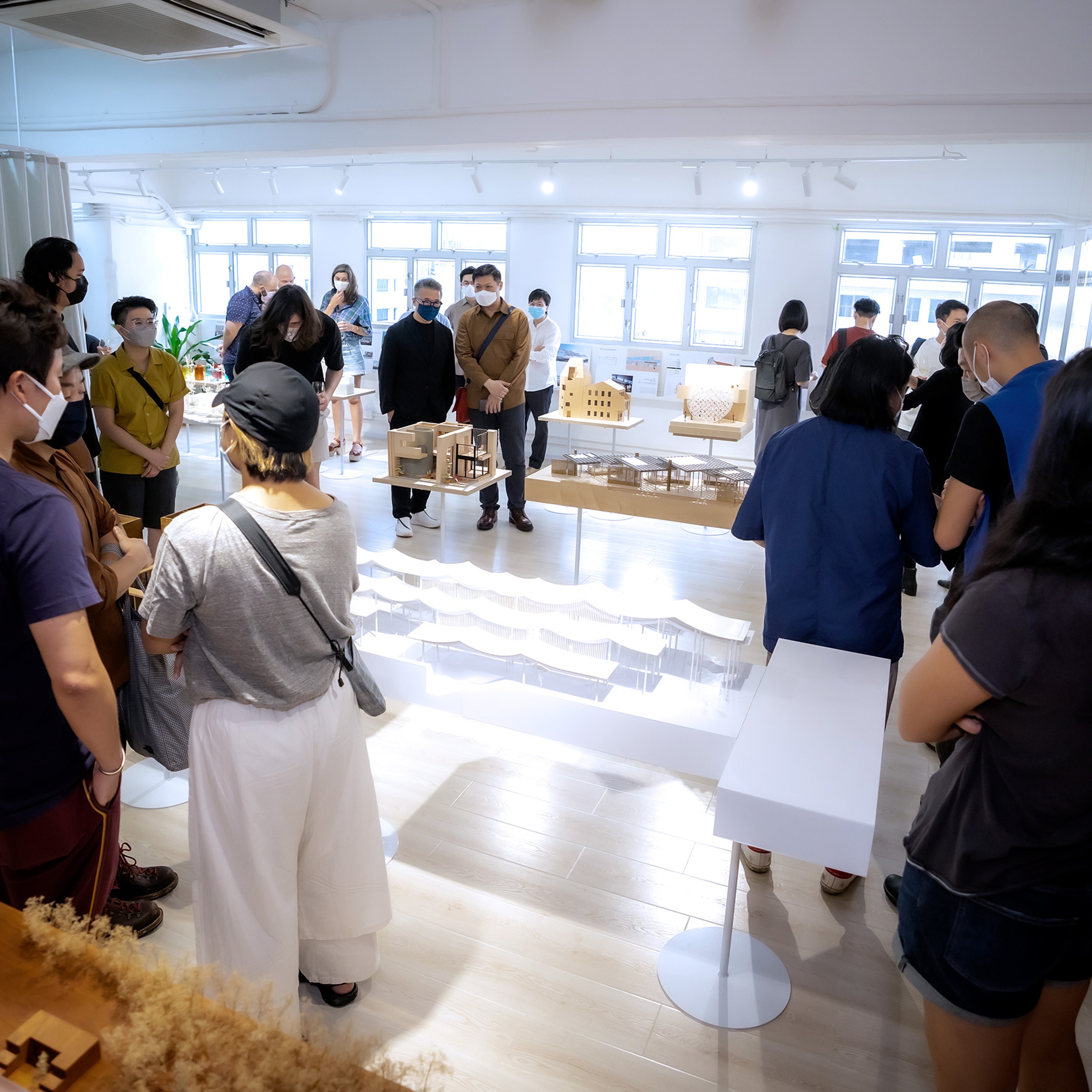 People standing around an architecture exhibit inside architecture studio