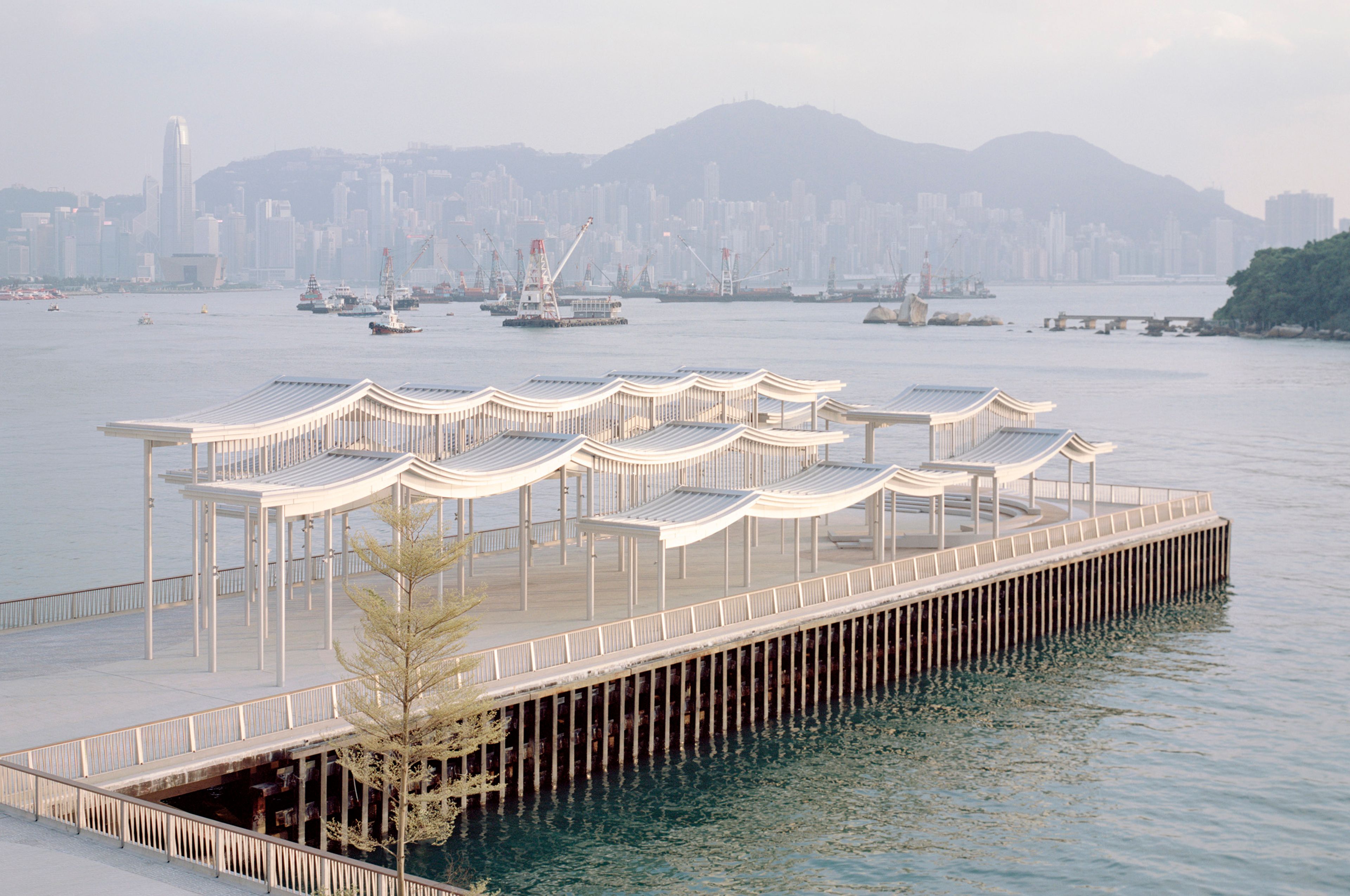 View of undulating pier canopy and Hong Kong skyline in background