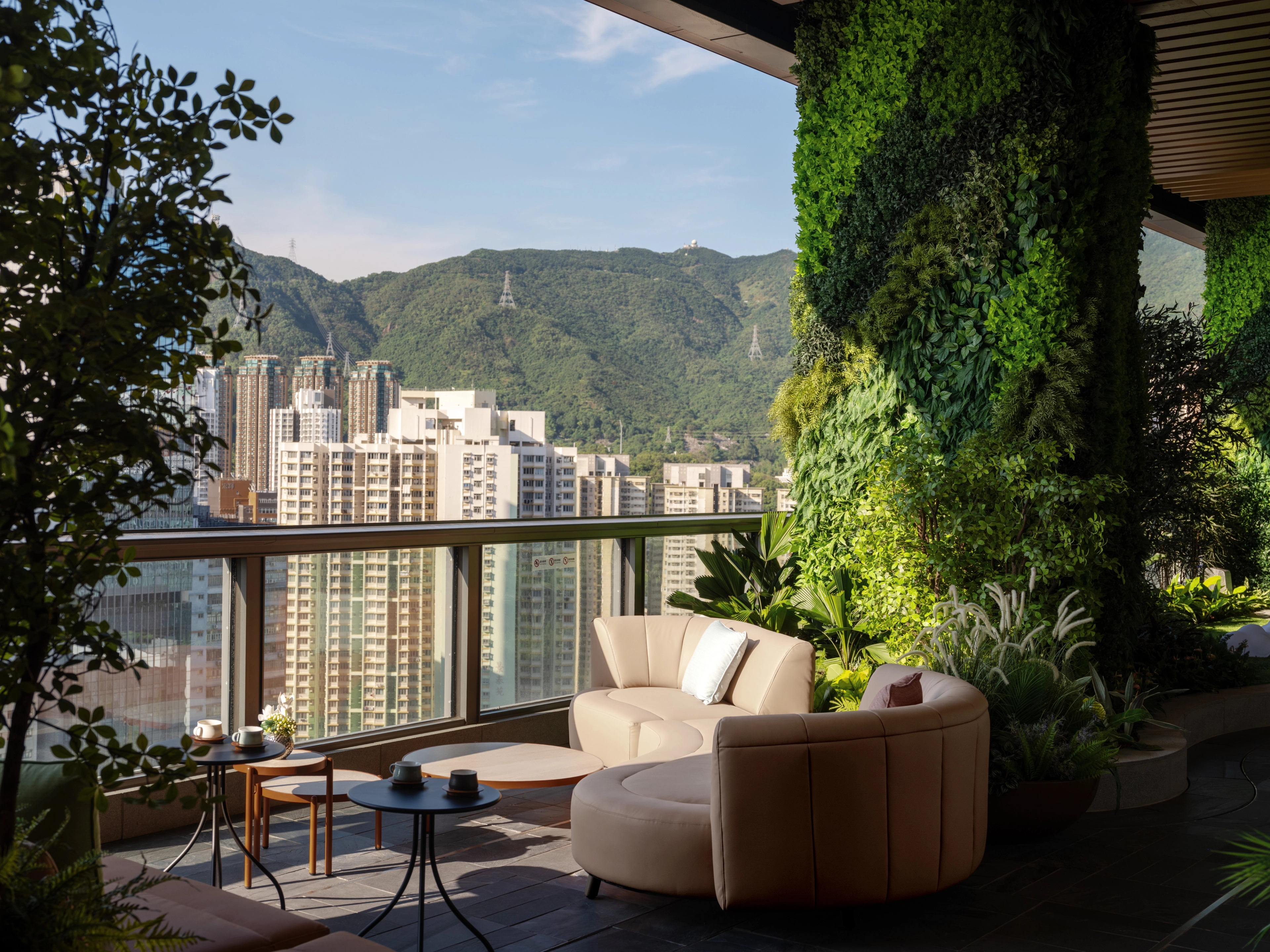 Lounge with natural sunlight and green column, set against picturesque mountain backdrop
