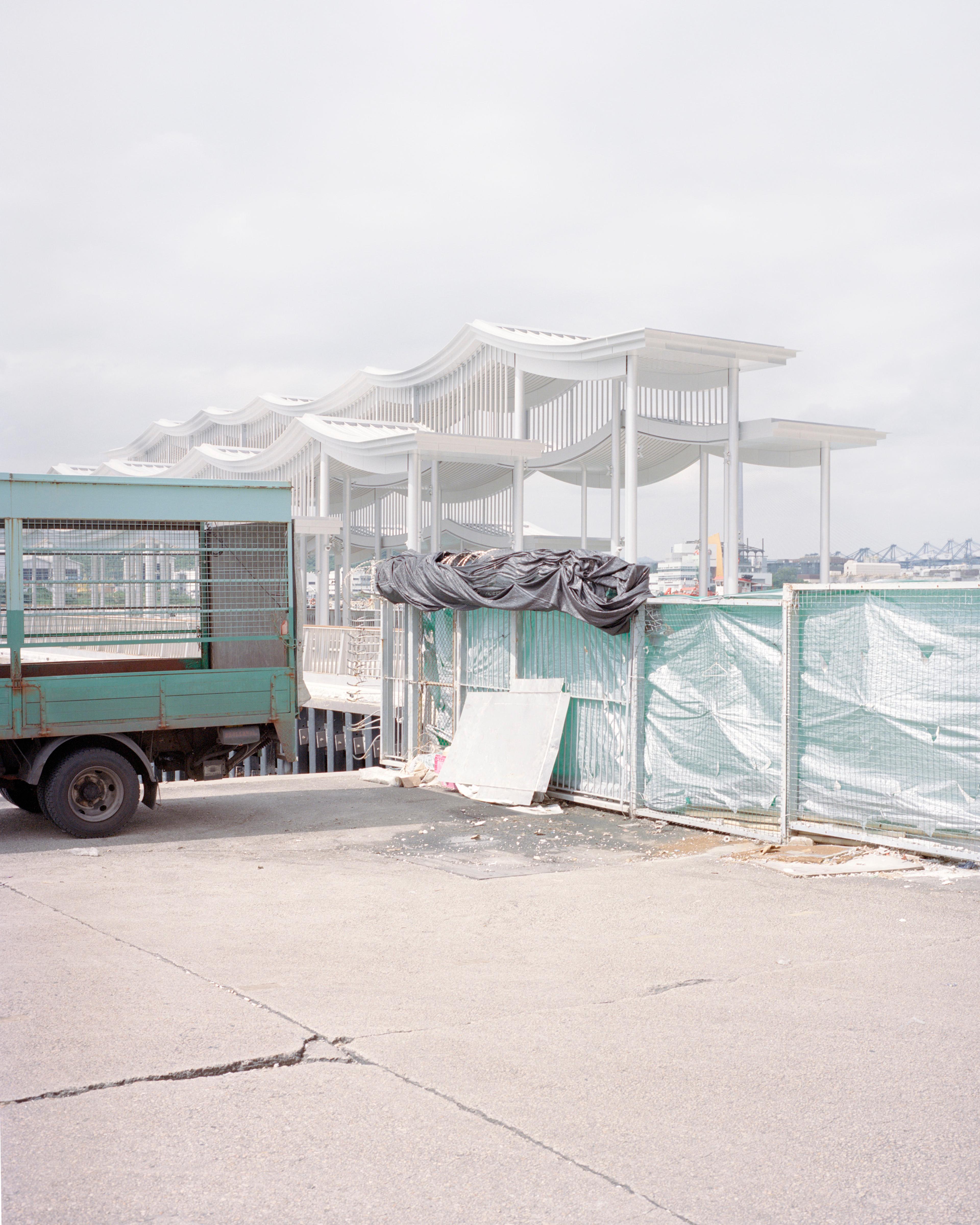 Silver pier canopy with truck and tarp in foreground