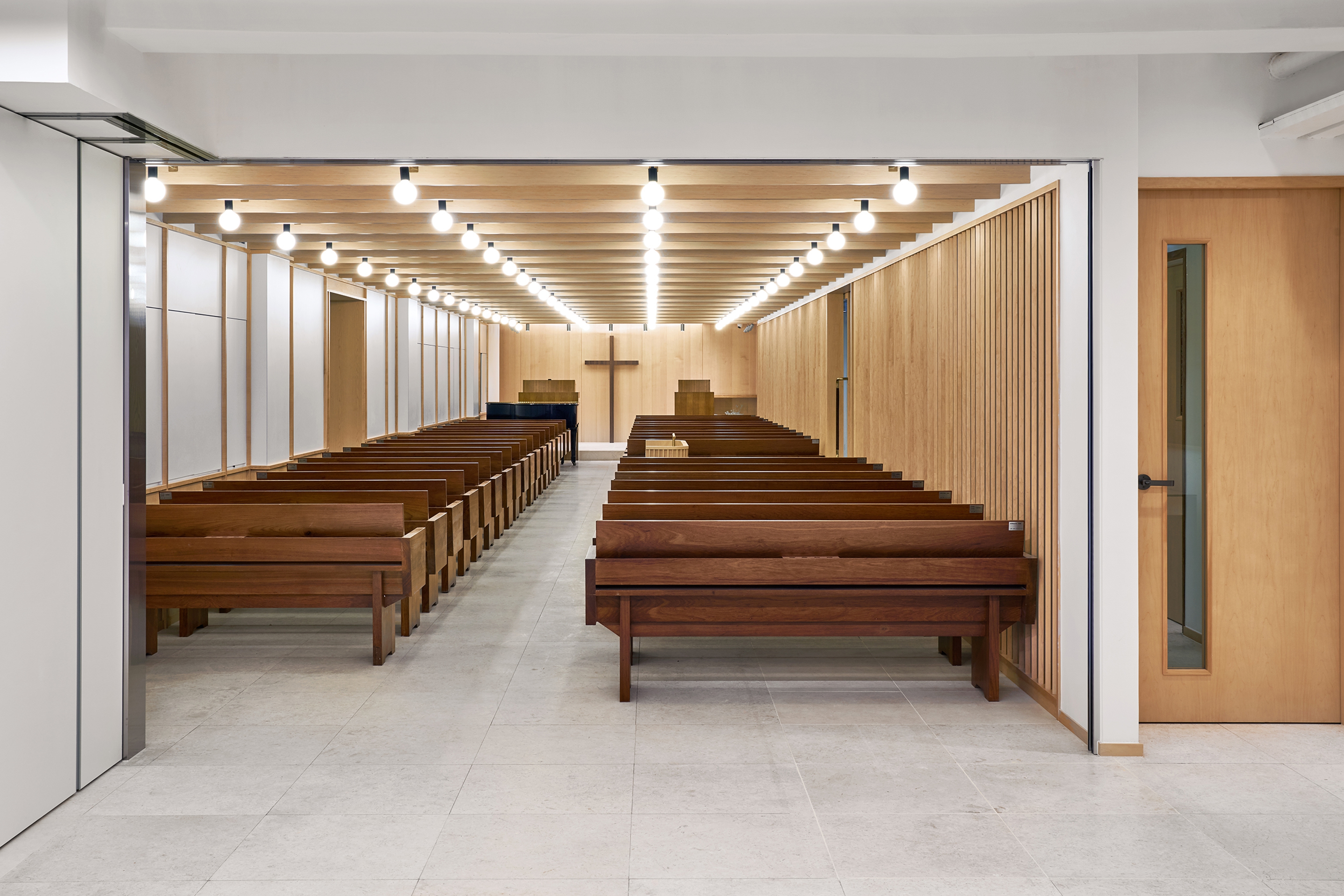 modern church interior with pews and cross in background