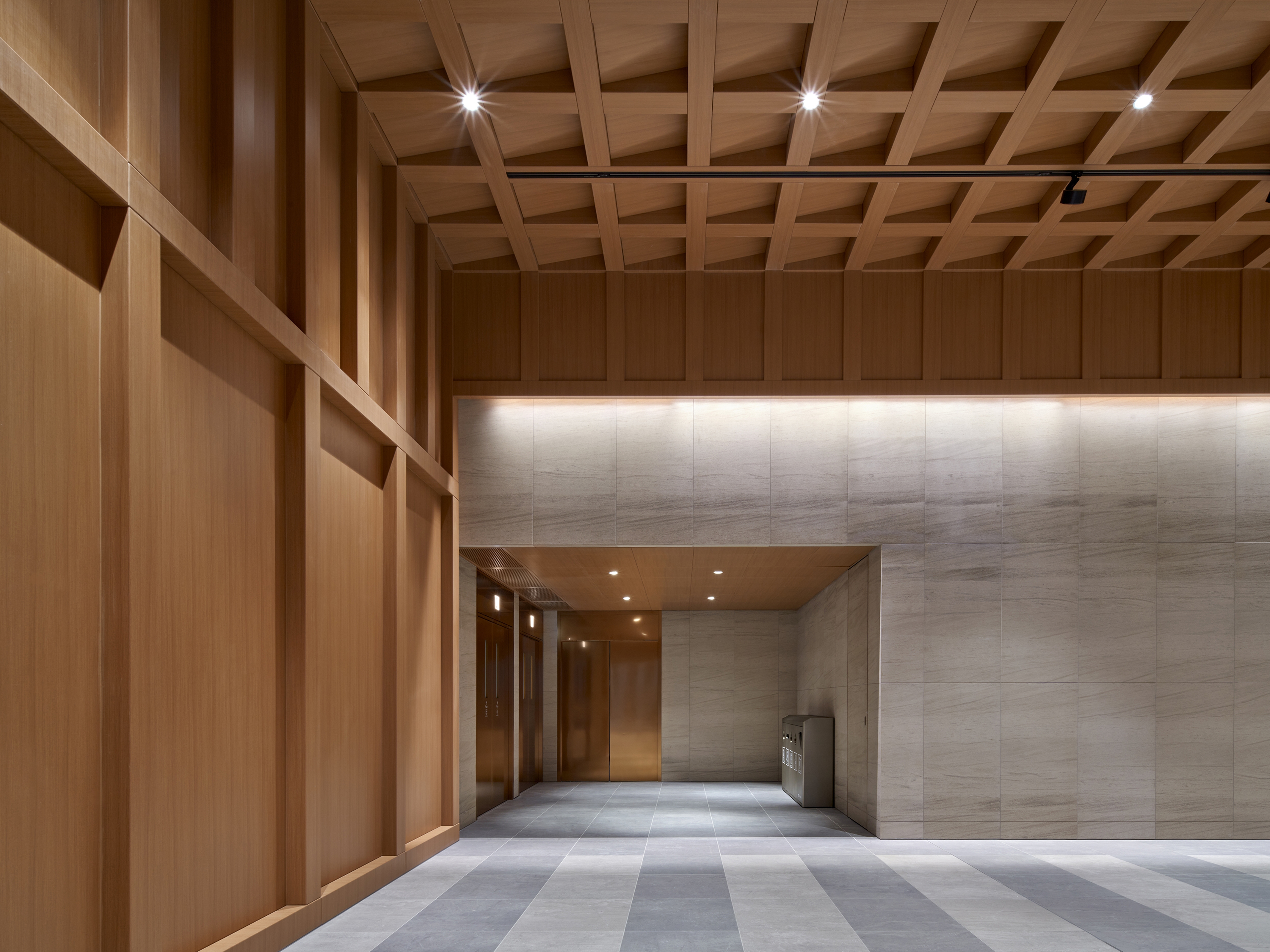 Atrium with beige stone walls and timber grid ceiling