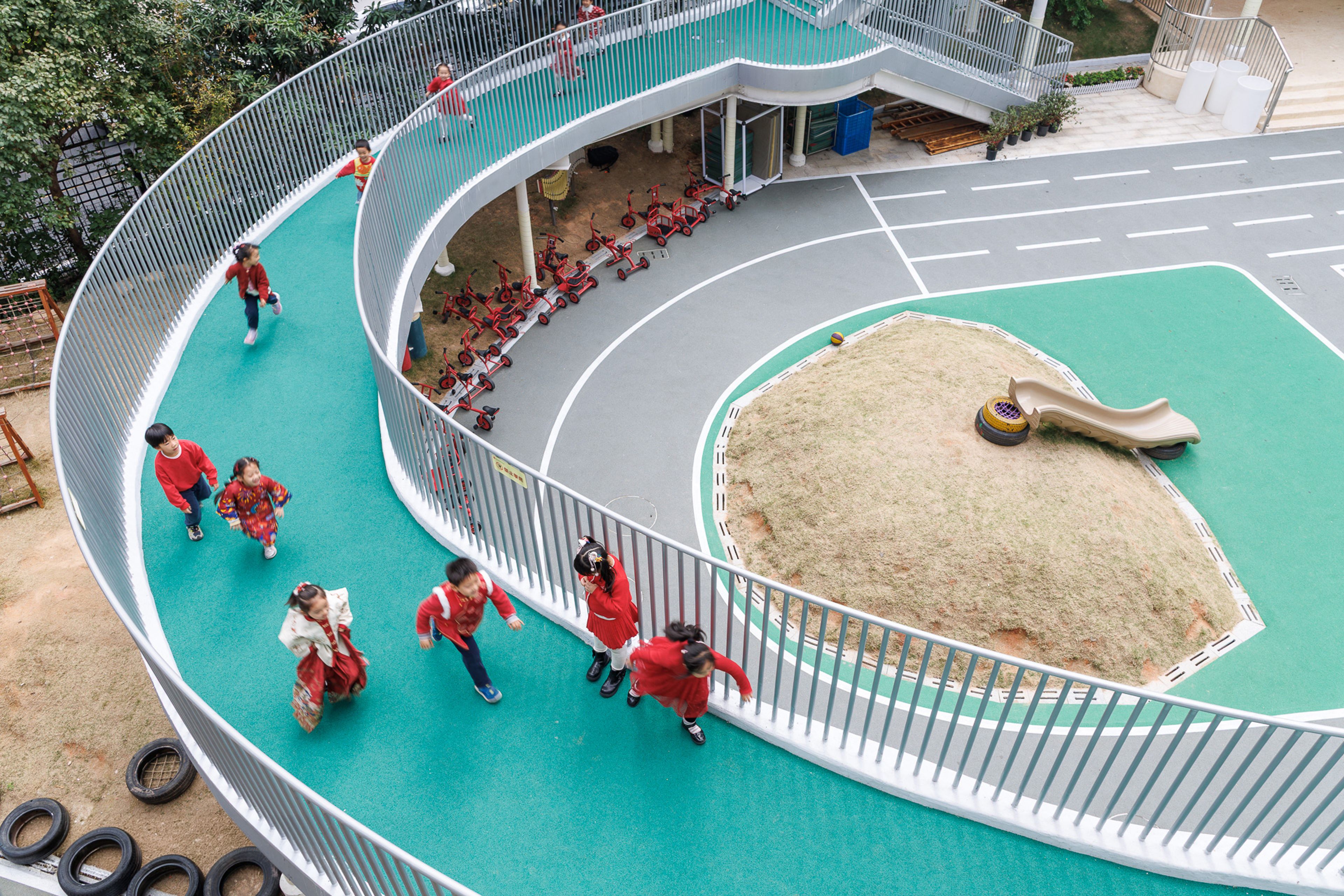 children running along a curved platform above playground