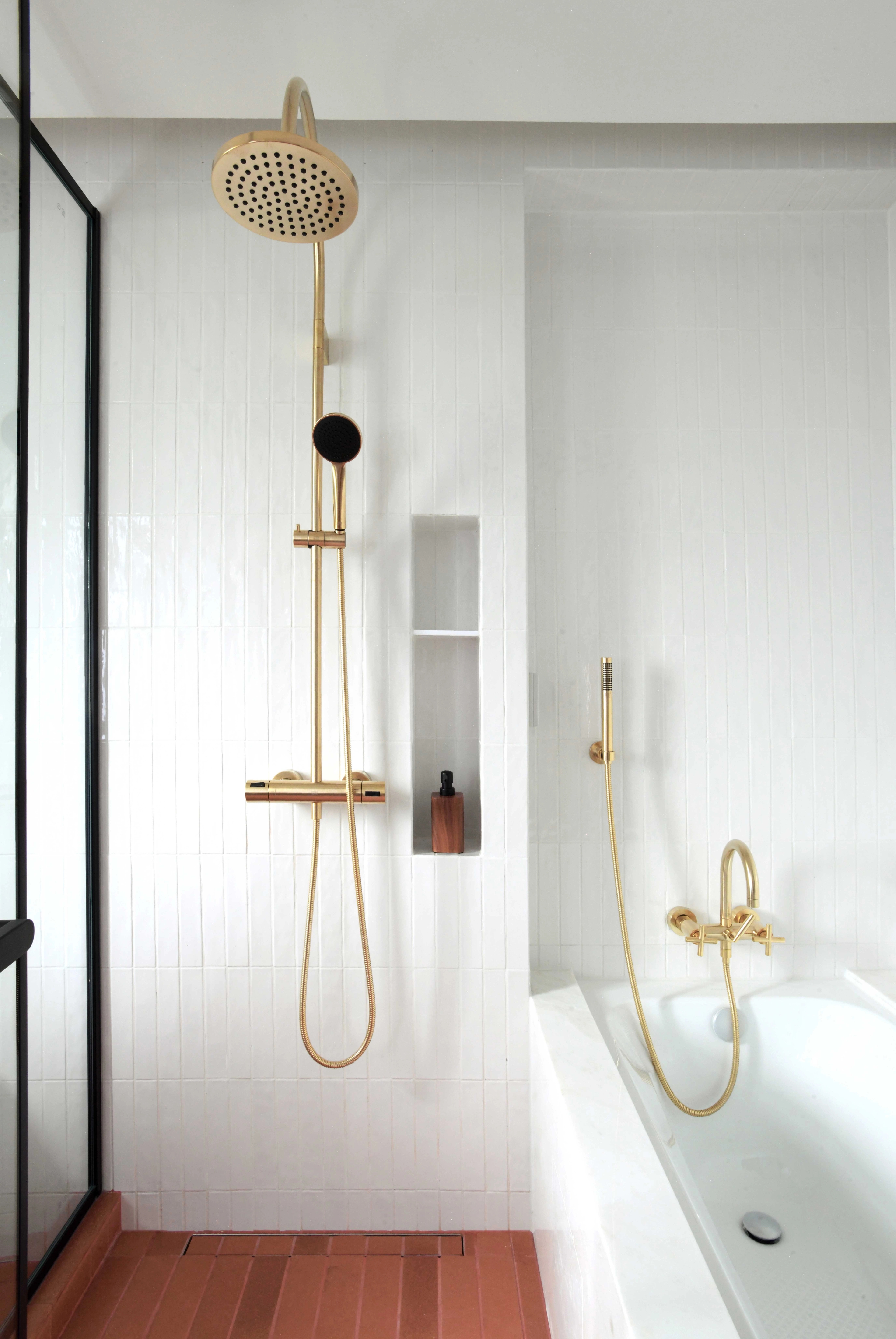shower room with glazed white ceramic tile and earthy terracotta floor