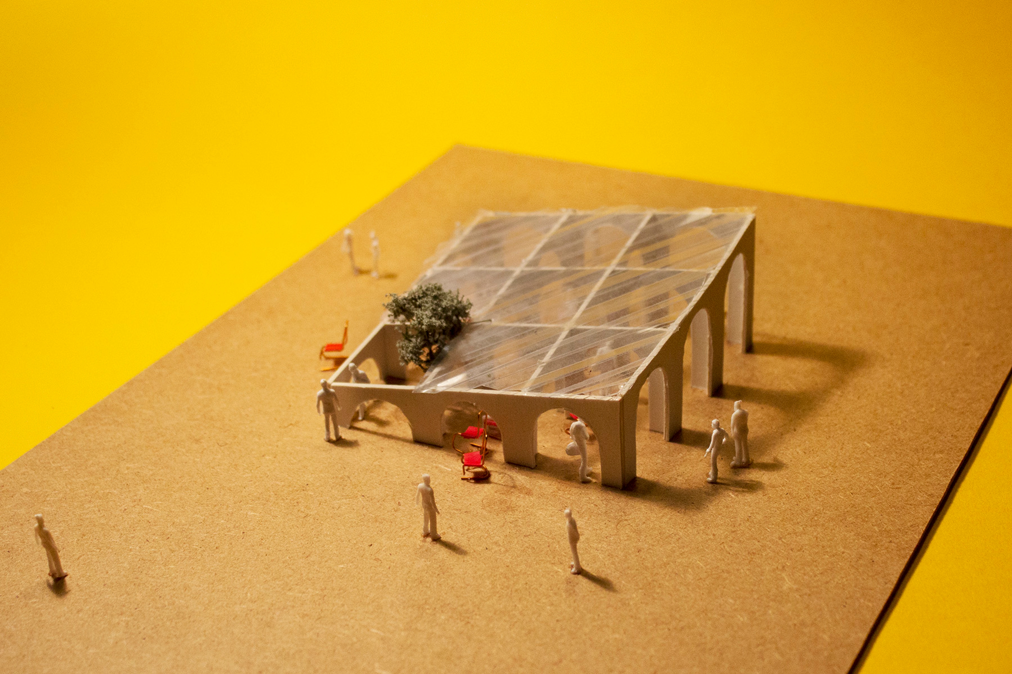 Architectural model of pavilion with chairs and people with a yellow background 