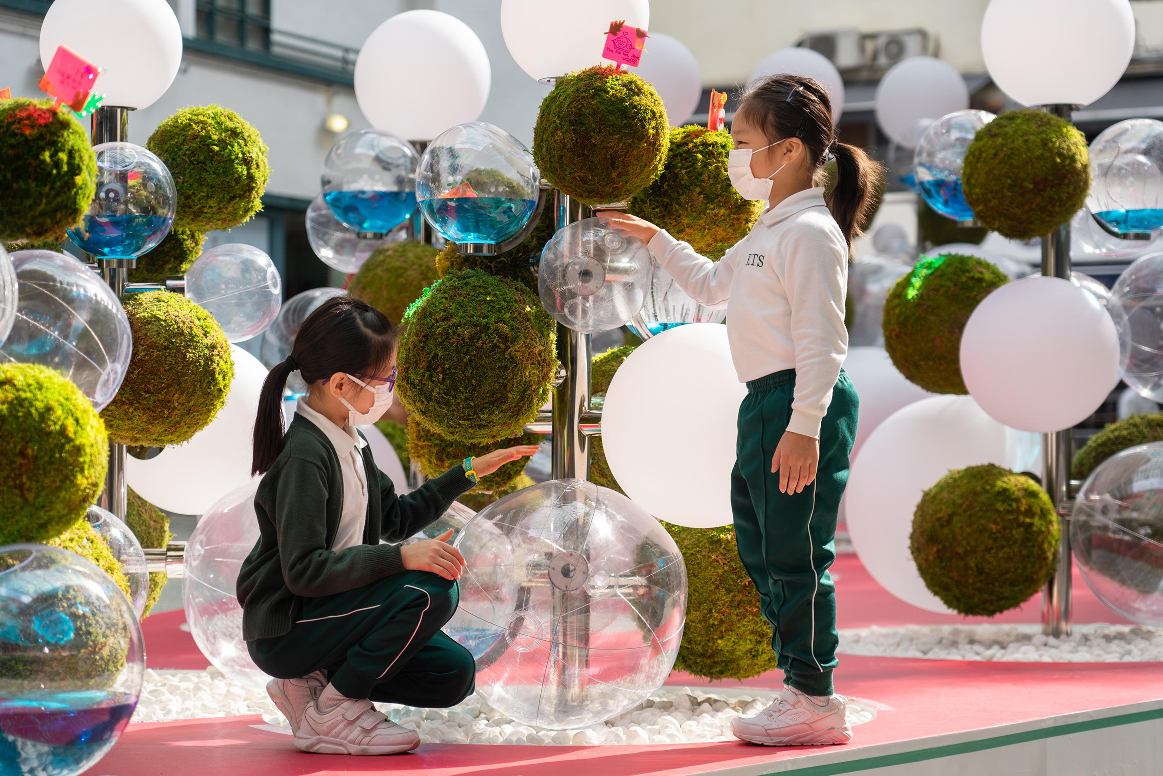 Close up children playing with christmas display within building courtyard in PMQ in Hong Kong