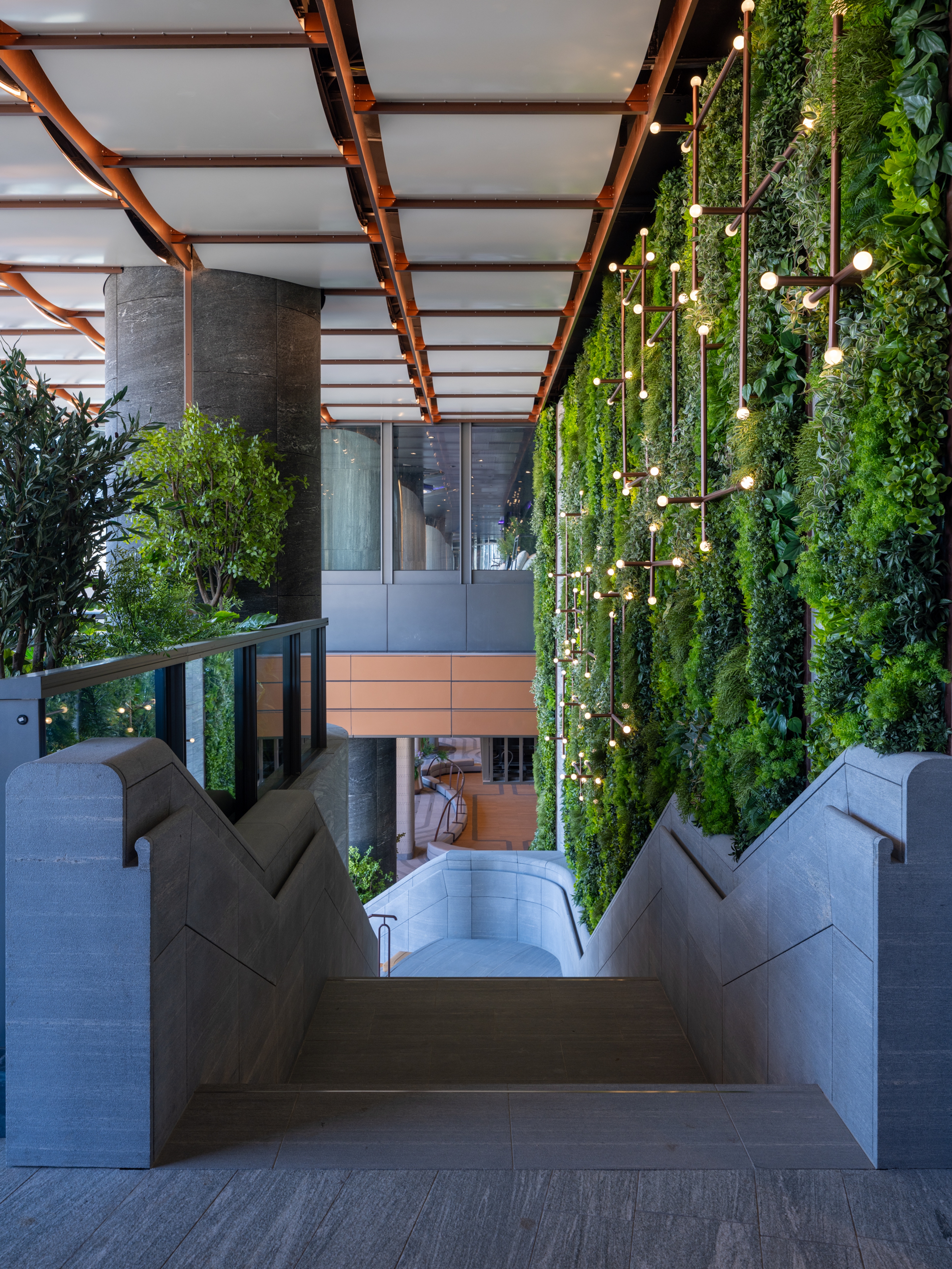 descending curved stone stair with lush green wall 