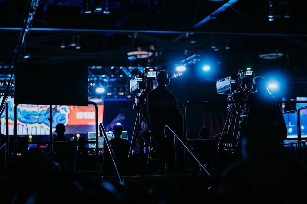 A small phone screen showing a livestream with very few viewers and a tired host holding a product