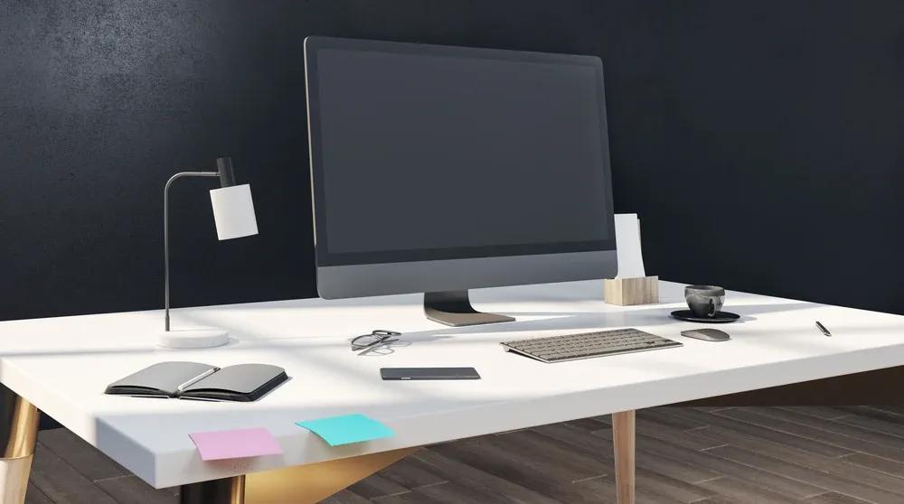 Clean modern office desk with monitor keyboard and lamp representing a professional google ad copy tool workflow