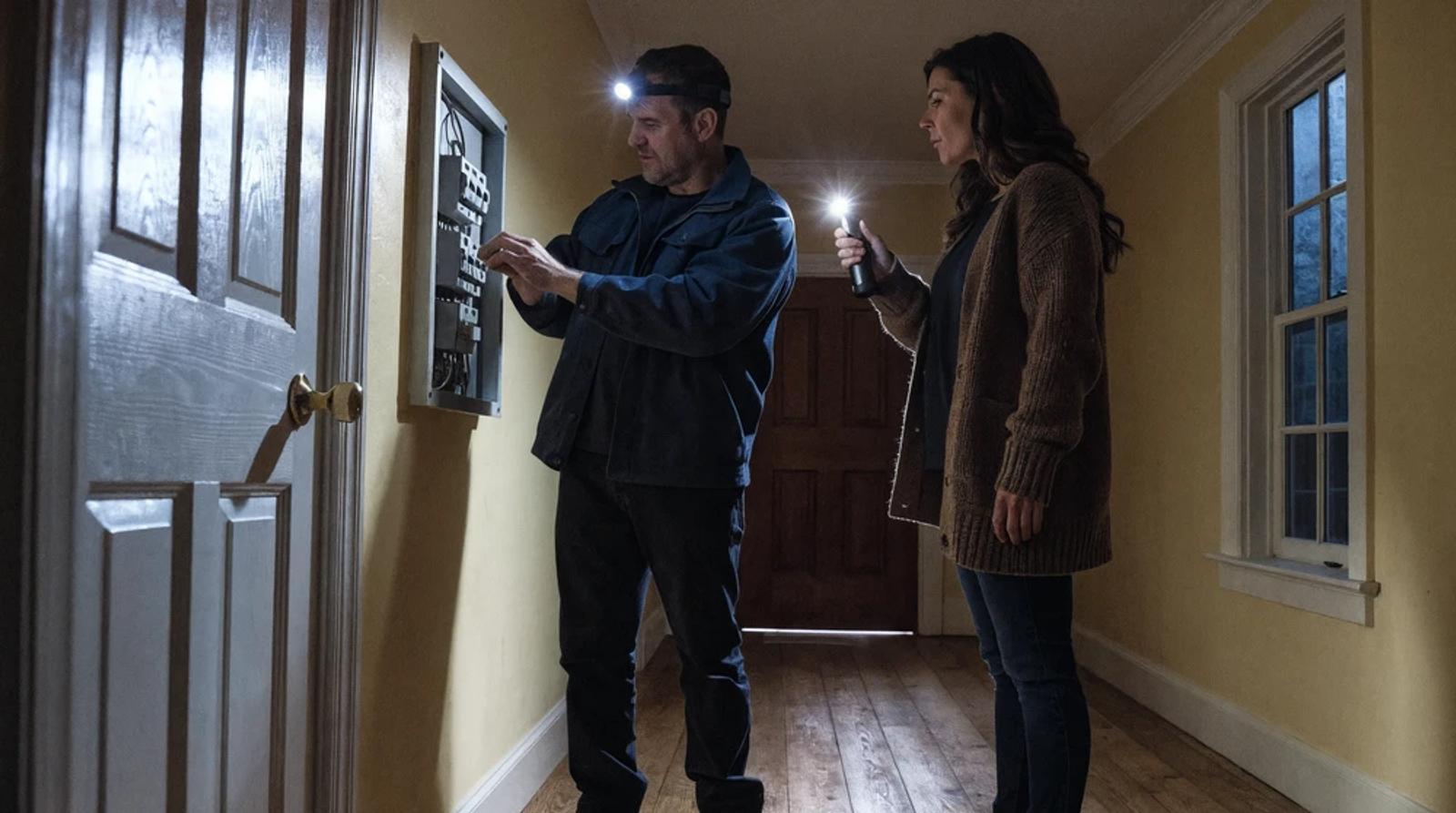 Electrician with a headlamp checking a breaker panel during a power outage, the urgent call electrician local seo helps you win