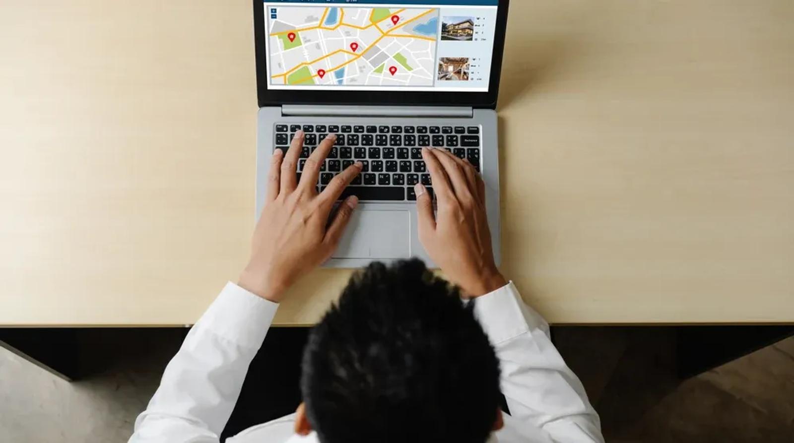 Franchise business owner reviewing multi-location Google Maps performance dashboard on laptop in modern office