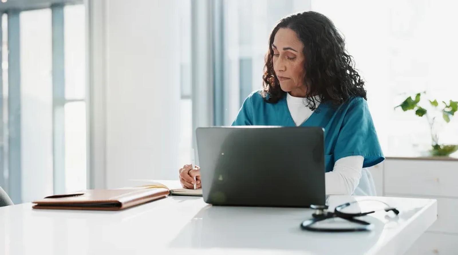 Healthcare professional reviewing patient data on a laptop representing local SEO for healthcare clinics