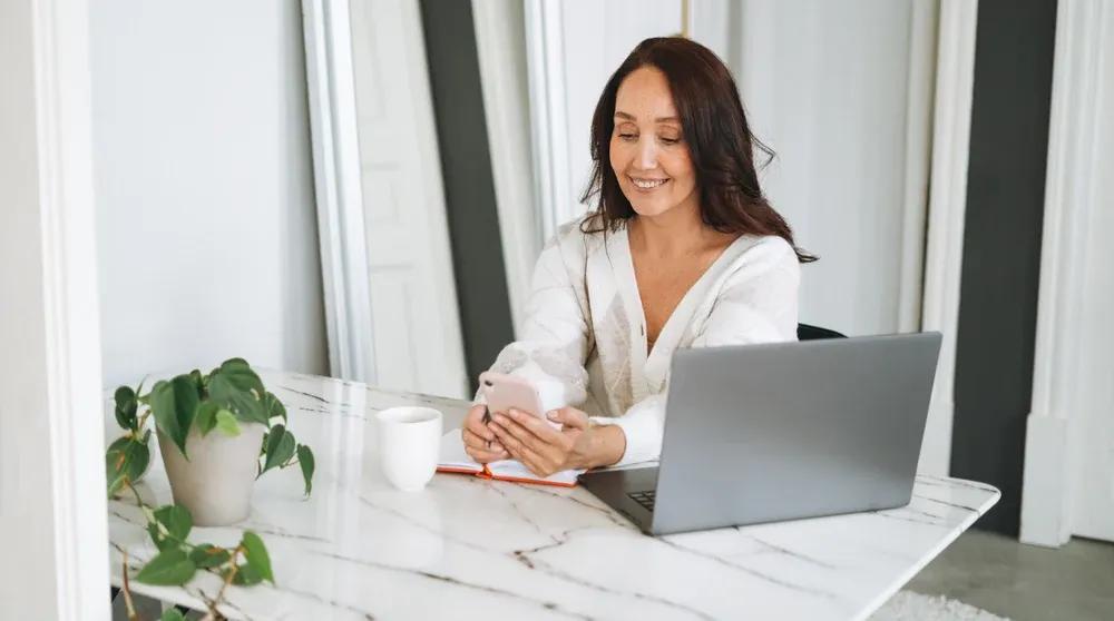 Business owner working on a laptop at a bright desk representing how to do a local seo audit for on-page signals