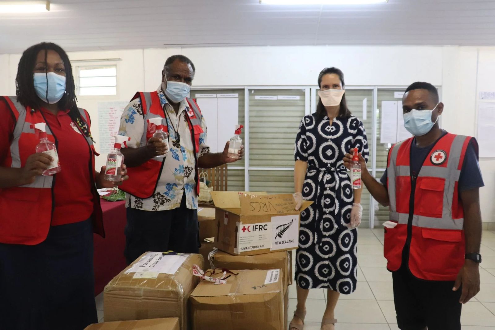The New Zealand High Commissioner Nicola Simmonds and Red Cross President, Moses Stevens and staff posing with the donated hand sanitizer. Photo: NZ HC