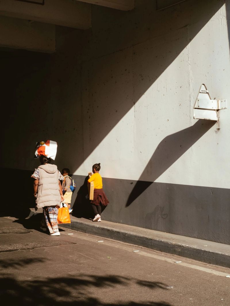 Famille disparaissant dans l'ombre du parking de leur immeuble dans le 13eme