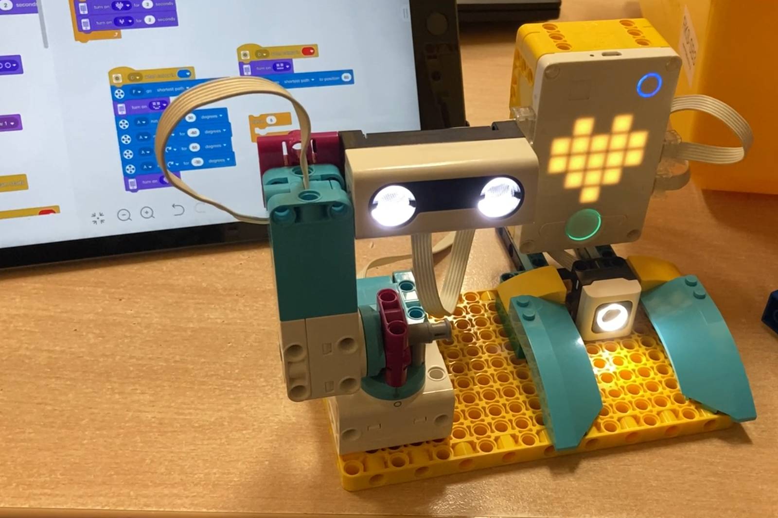 Starší dítě u robota ze SPIKE™ Prime s tabletem a programem ve SCRATCHi