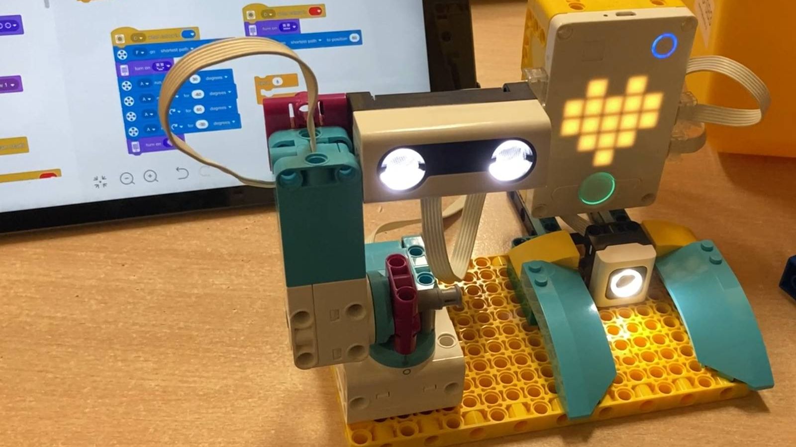 Starší dítě u robota ze SPIKE™ Prime s tabletem a programem ve SCRATCHi