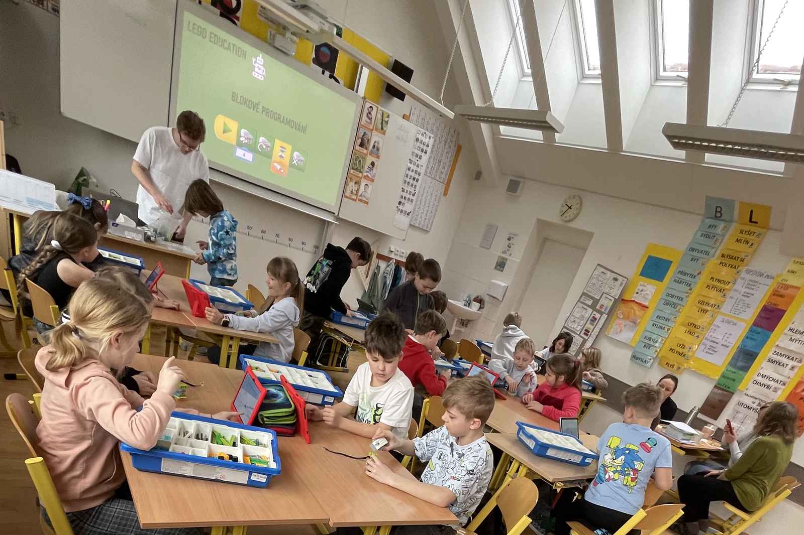 Lekce robotiky Robokids ve školní třídě, děti staví LEGO roboty ve dvojicích