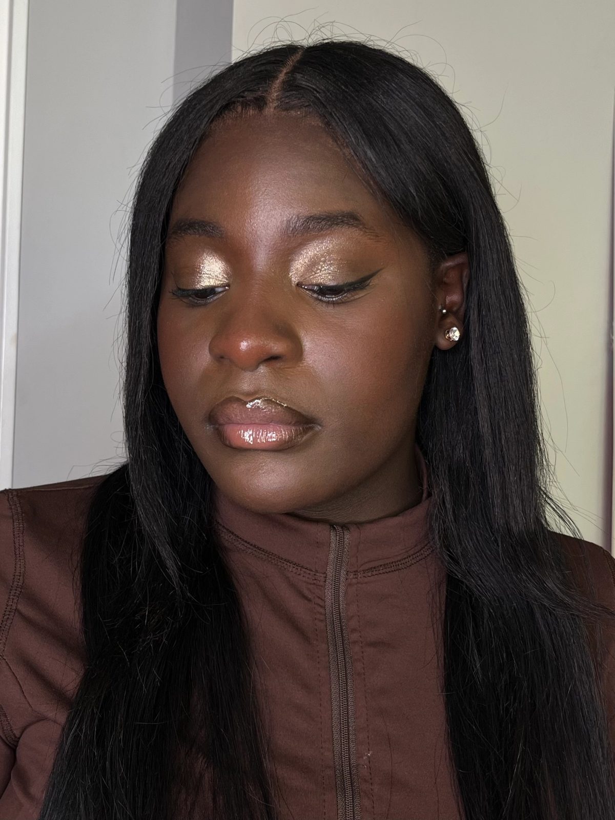 Maquillage de soirée : paupières dorées, liner noir et lèvres glossy